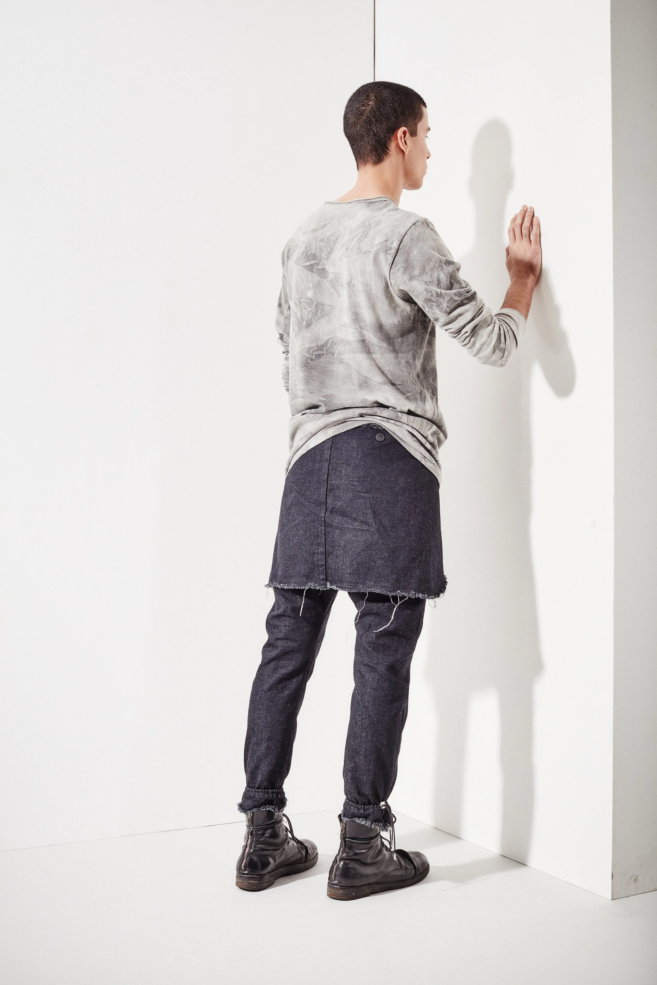 Editoriale moda uomo per Kolonko, con modello di spalle in look grigio e denim, fotografato da Paolo Esposito