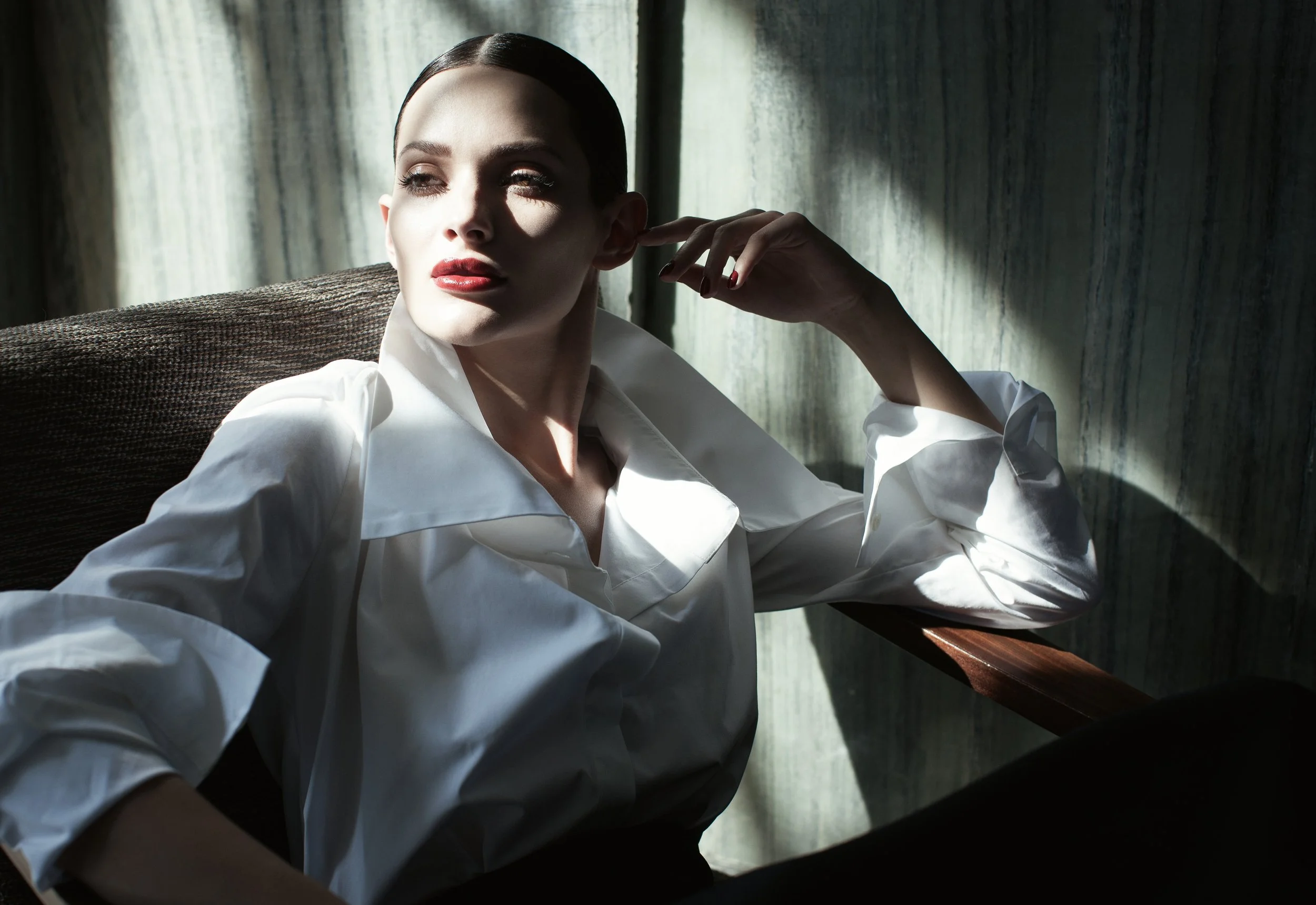 Modella in camicia bianca illuminata da fasci di luce netta, fotografia moda di Paolo Esposito per Tomaso Stefanelli.