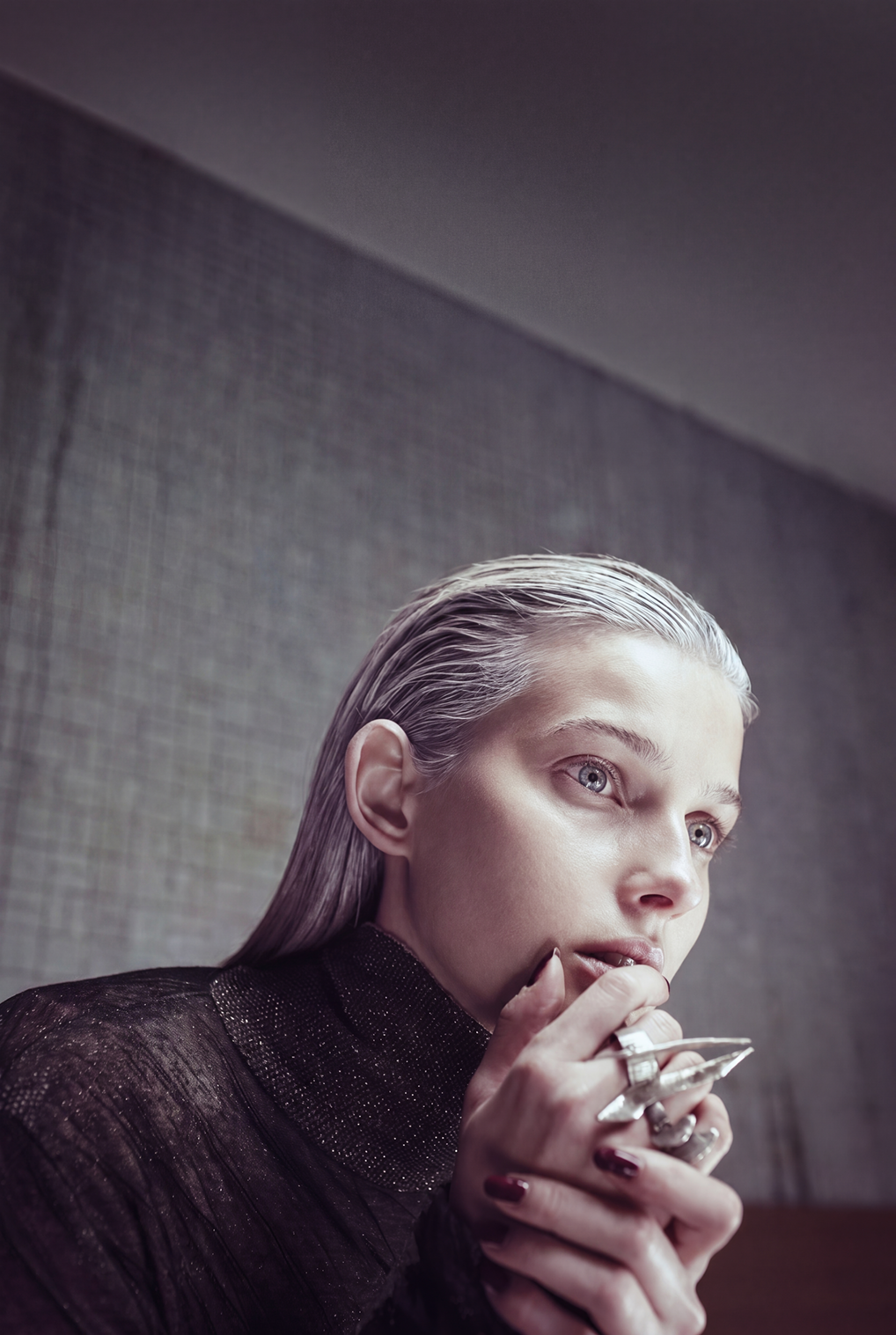 Ritratto ravvicinato di una modella con capelli effetto bagnato, top nero e gioiello-scultura in metallo di Tom Rebl, serie Underground Disorder di Paolo Esposito.