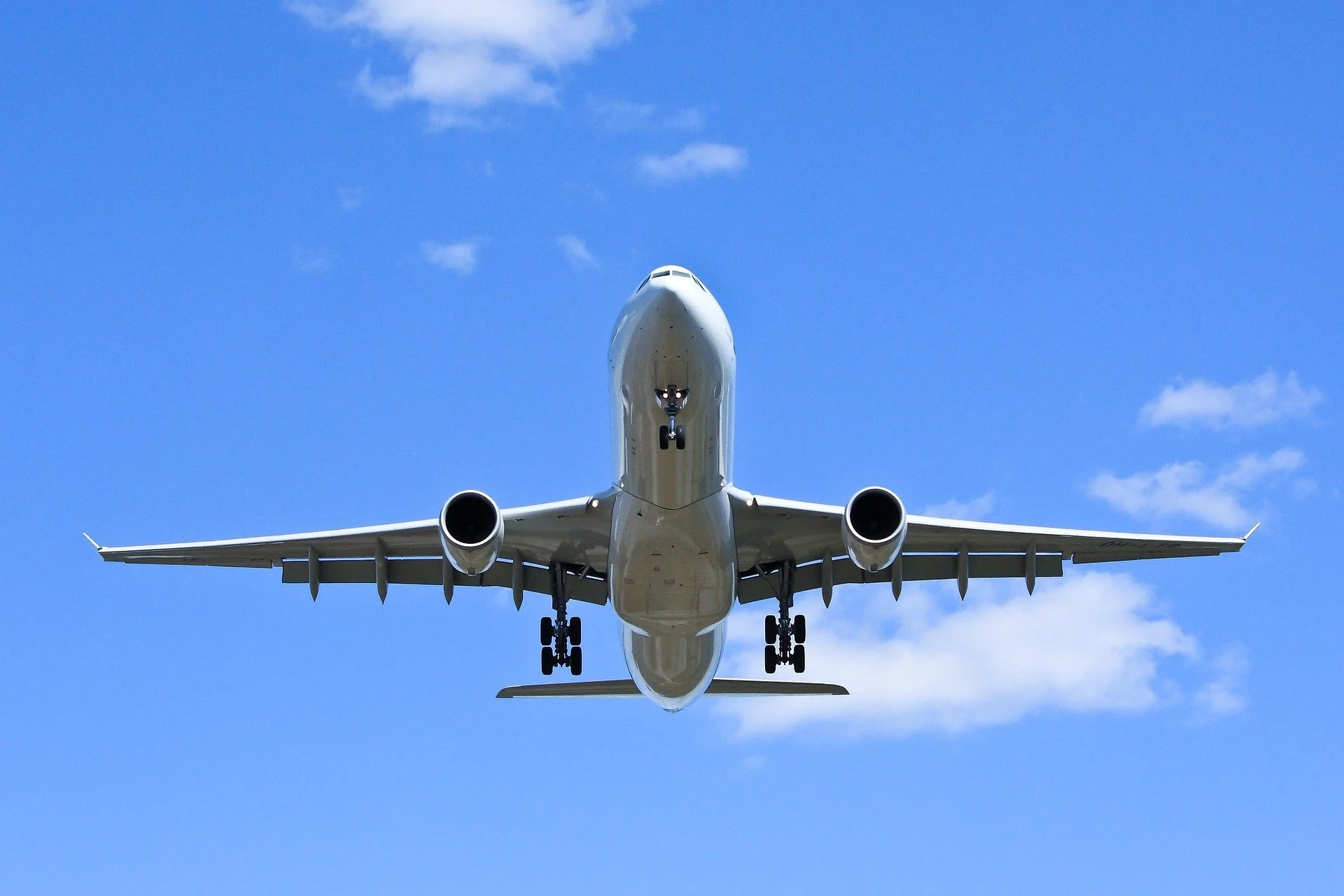 Commercial airplane flying overhead against a blue sky