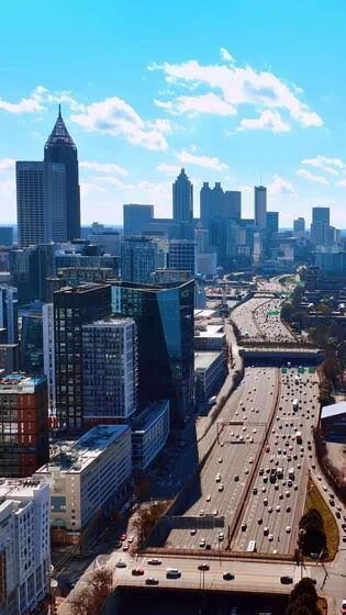 Downtown Atlanta skyline with skyscrapers and a busy highway.