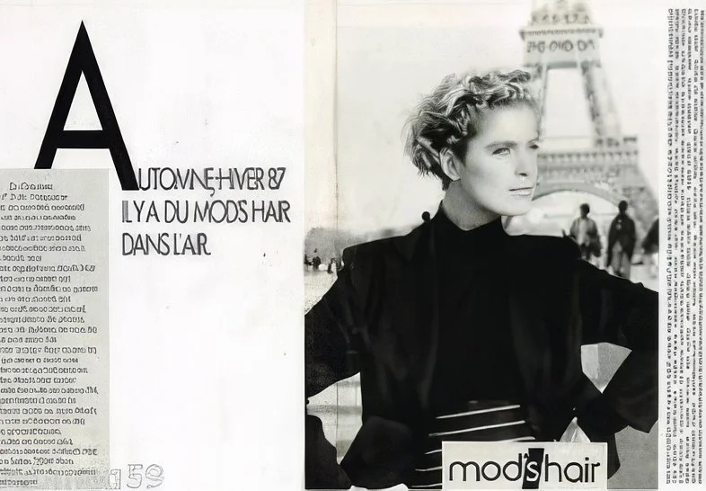 Black and white fashion photo of a woman with styled short hair, standing near the Eiffel Tower with a city background, with text and magazine elements around her.
