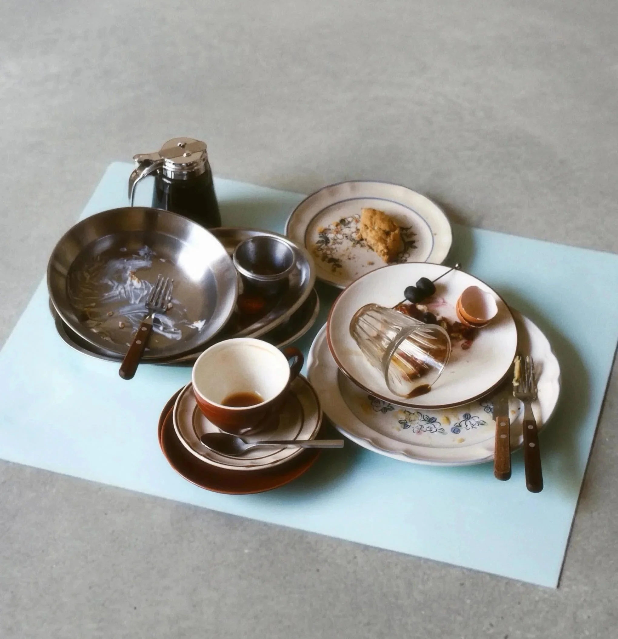 platos, cubiertos, tazas y restos de desayuno, comida y cena sobre una mesa