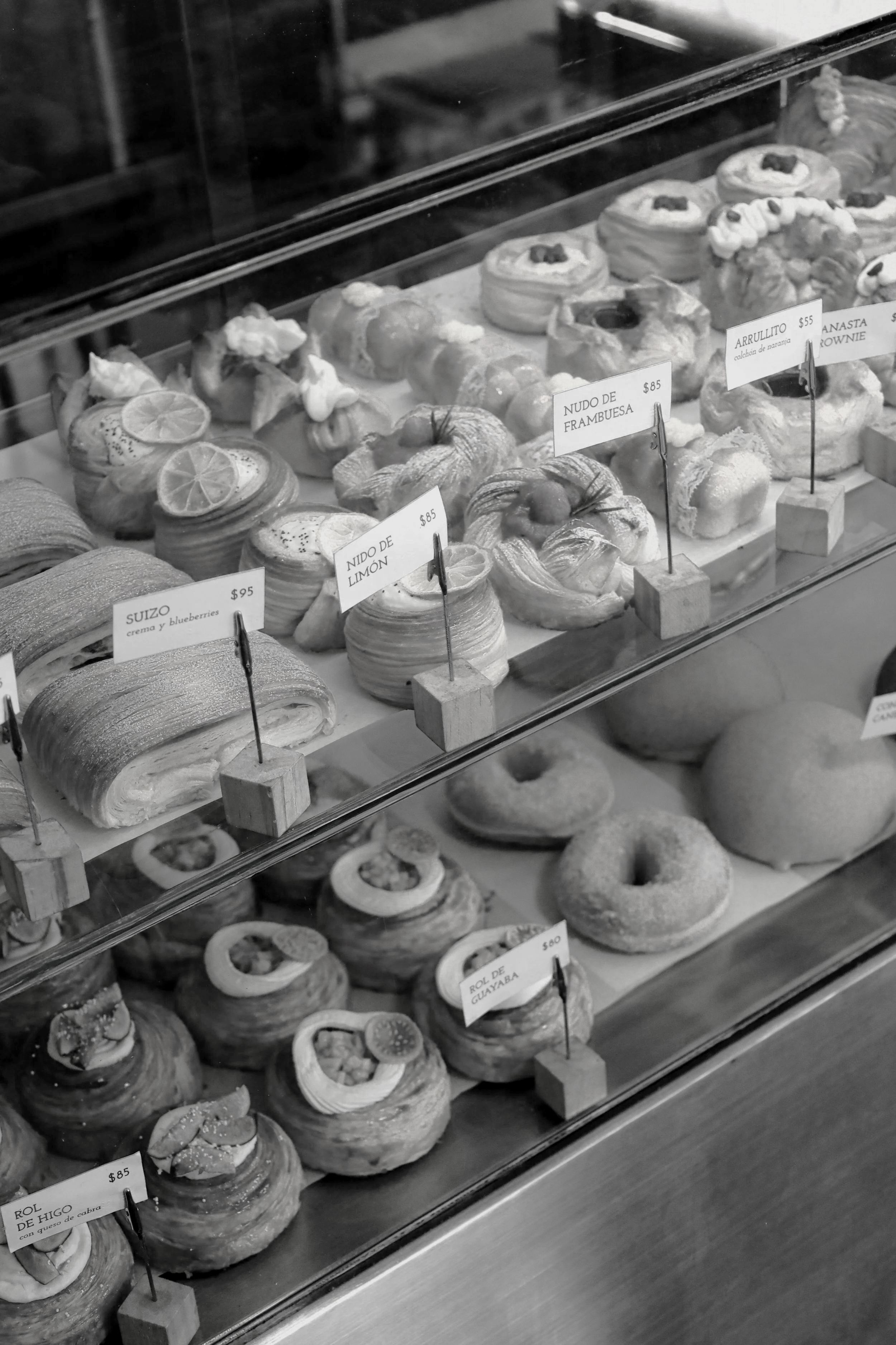 Vitrina con diferentes tipos de pan que ofrecemos en Arrullo que incluyen panes y postres regulares, veganos y sin gluten disponibles durante el desayuno, comida y cena en Oaxaca.