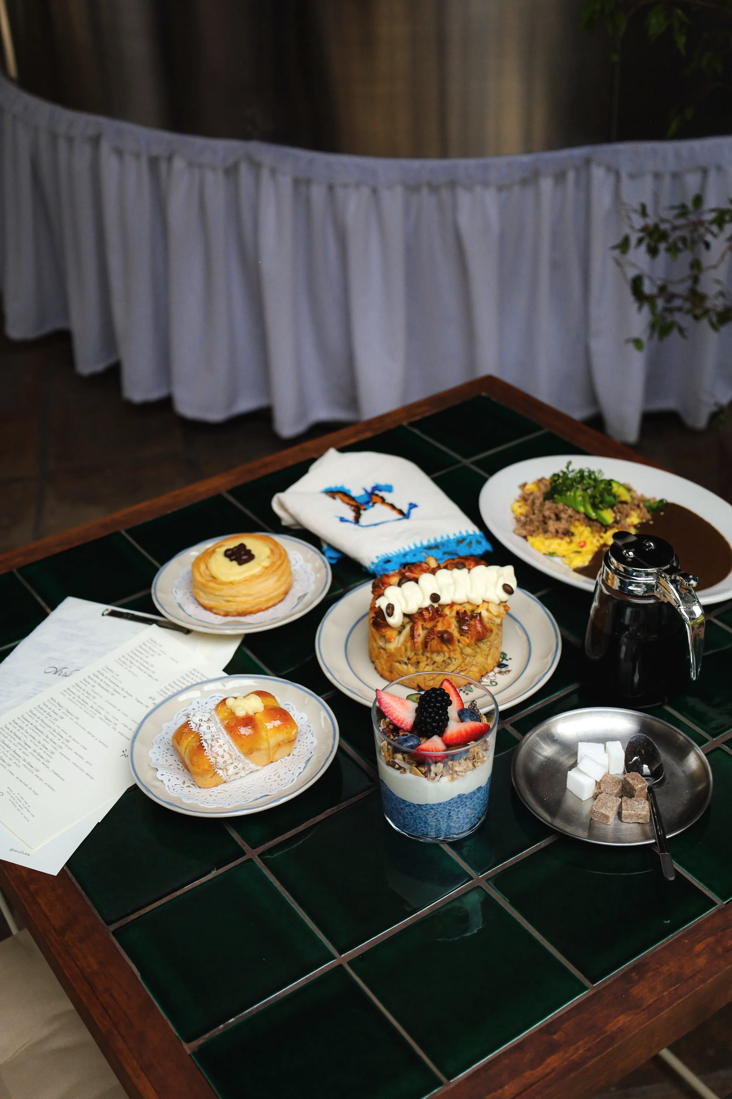Mesa con diversos postres, frutas, café y refrigerios en la terraza de Arrullo Oaxaca.
