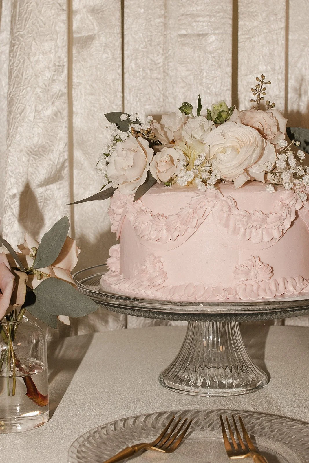 Pink wedding cake with white flowers on a glass cake stand - wedding day management in Omaha by Renae Events
