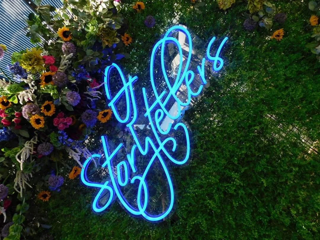Covenant Children's Storytellers. Custom neon signage designed by Gather by Autry and created by a trusted subcontractor over a gorgeous greenery backdrop provided by Fig & Flower.