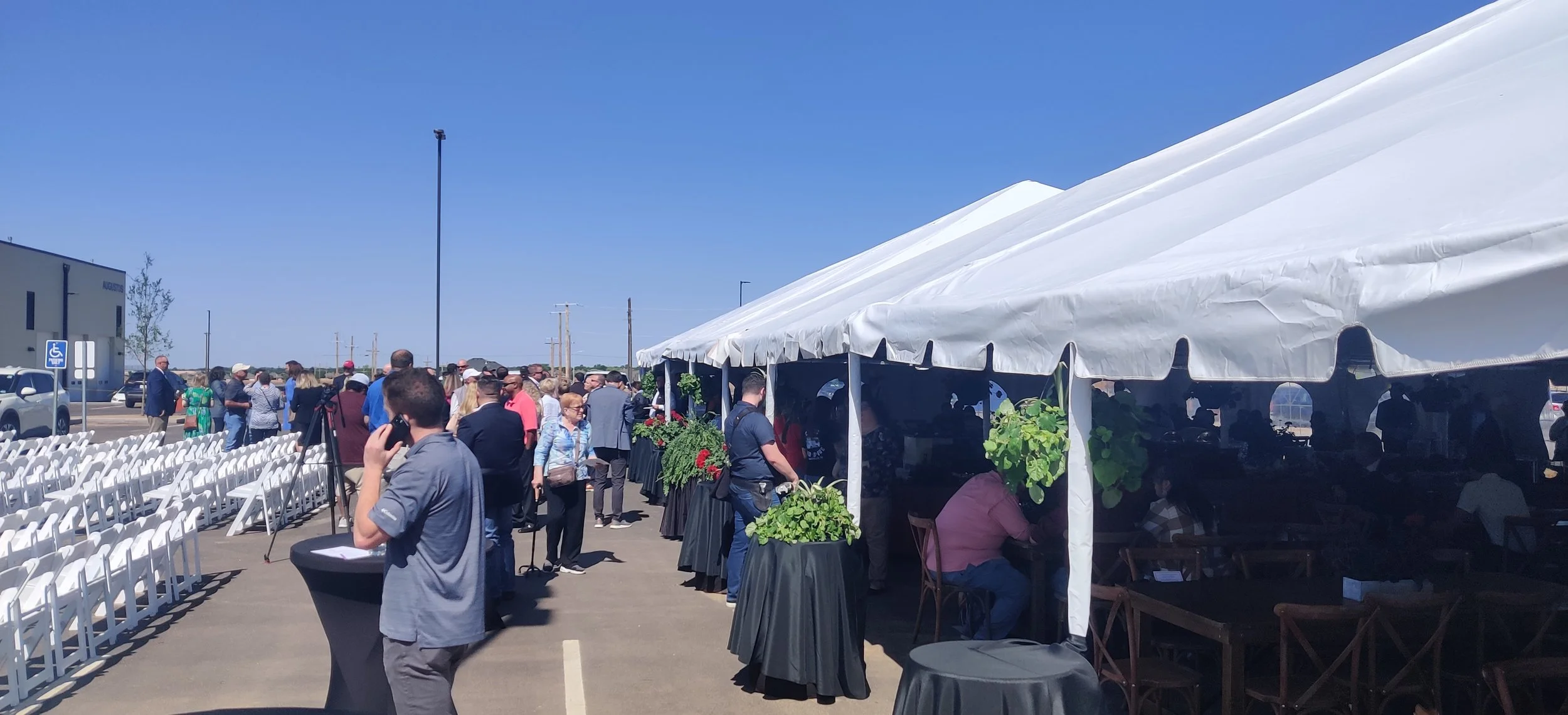 Factory Ribbon Cutting. Lunch is protected from the sun and wind by tents and decorated with live plants and florals.