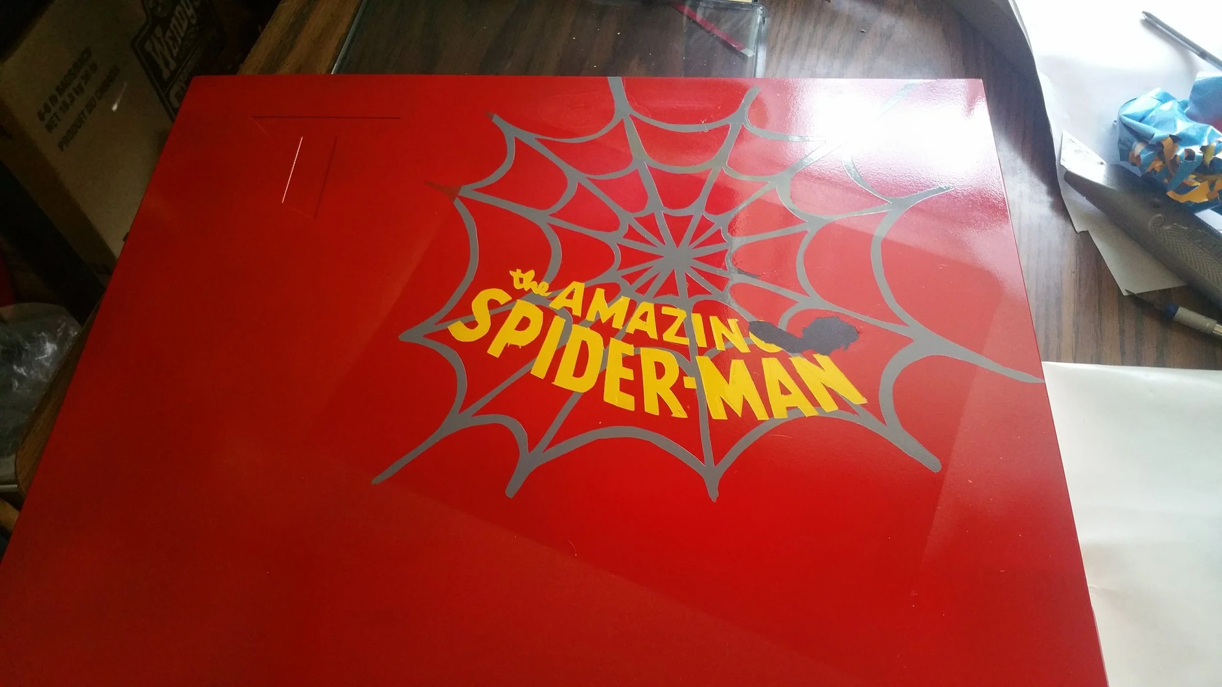 The hand made stencil was done using vinyl.  The paint did not fully dry before peeling leading to some mistakes.
Lesson learned, this is the back side of the case and honestly is very rarely seen.