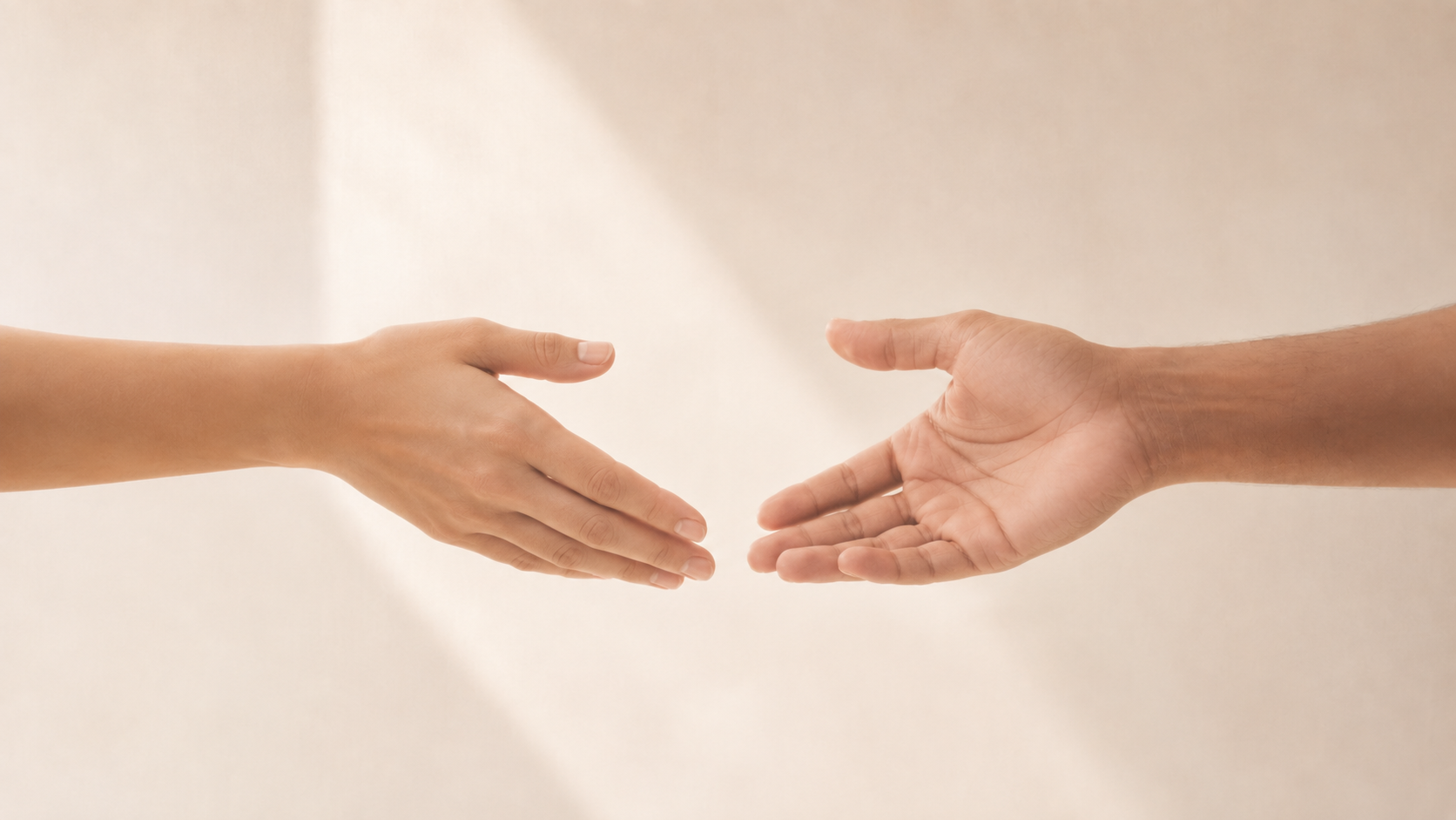 Two hands reaching towards each other, one from the left and one from the right, with a light beige background.