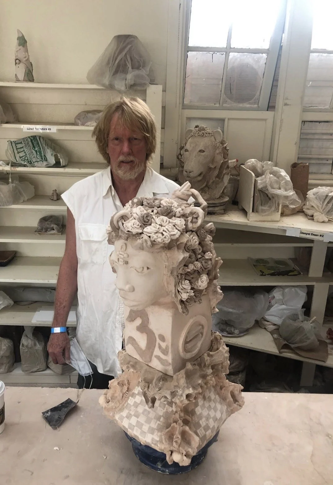 Visionary sculptor Eddie Hall stands next to his ceramic sculptures, featuring his masterwork 'Karma' in the foreground and 'Golden Lion' before being fired in the kiln.
