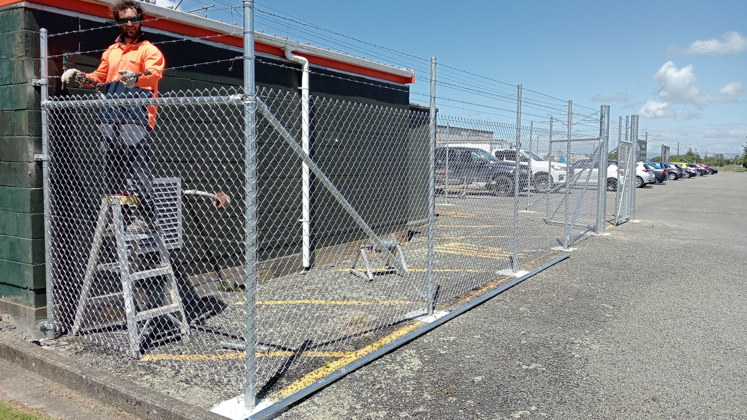 Installer fitting an aluminium fence panel