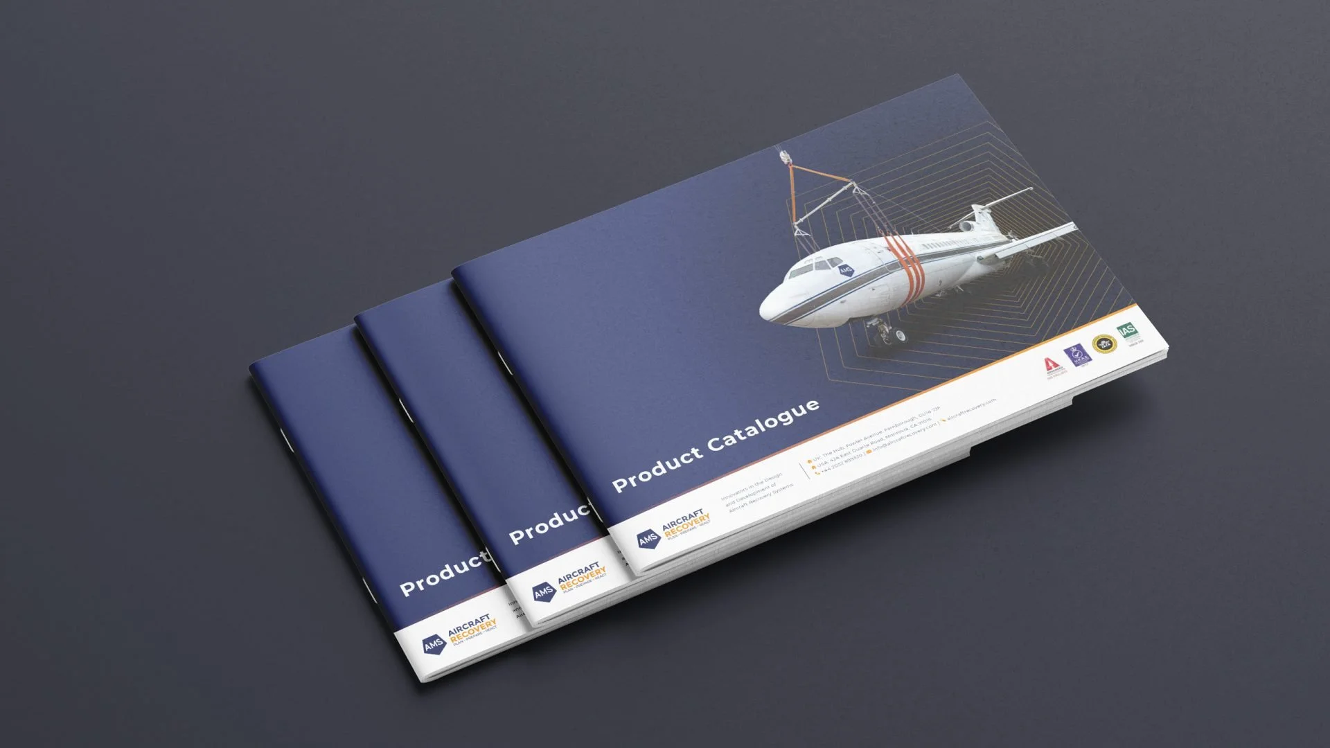 Several navy blue booklets stacked next to each other with the top booklet titled 'Product Catalogue'. The cover shows an illustration of an airplane with a design resembling a circuit board. The bottom of the cover has logos and contact information.