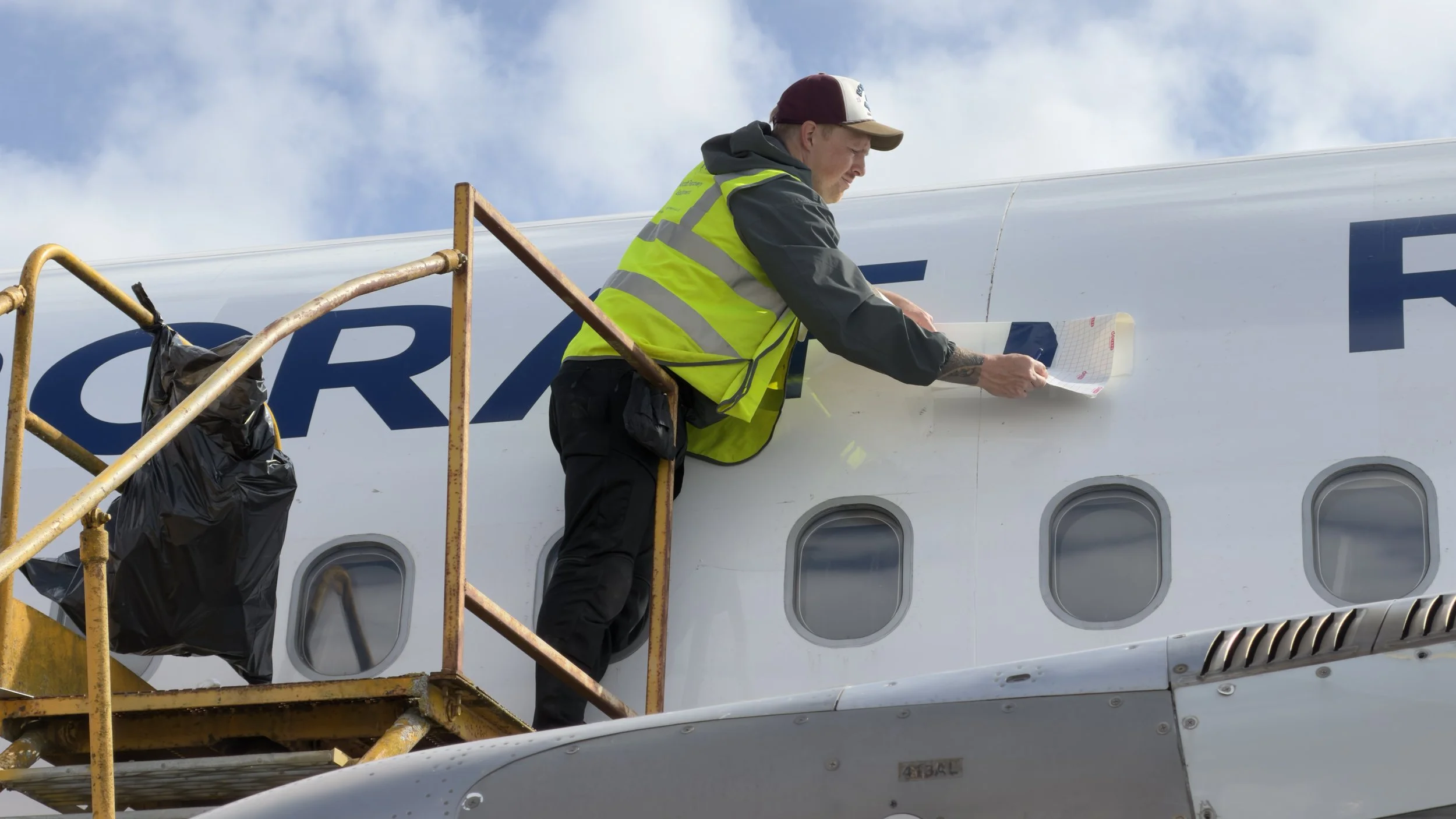 AMS Aircraft Recovery vinyl logo being applied to an aircraft fuselage