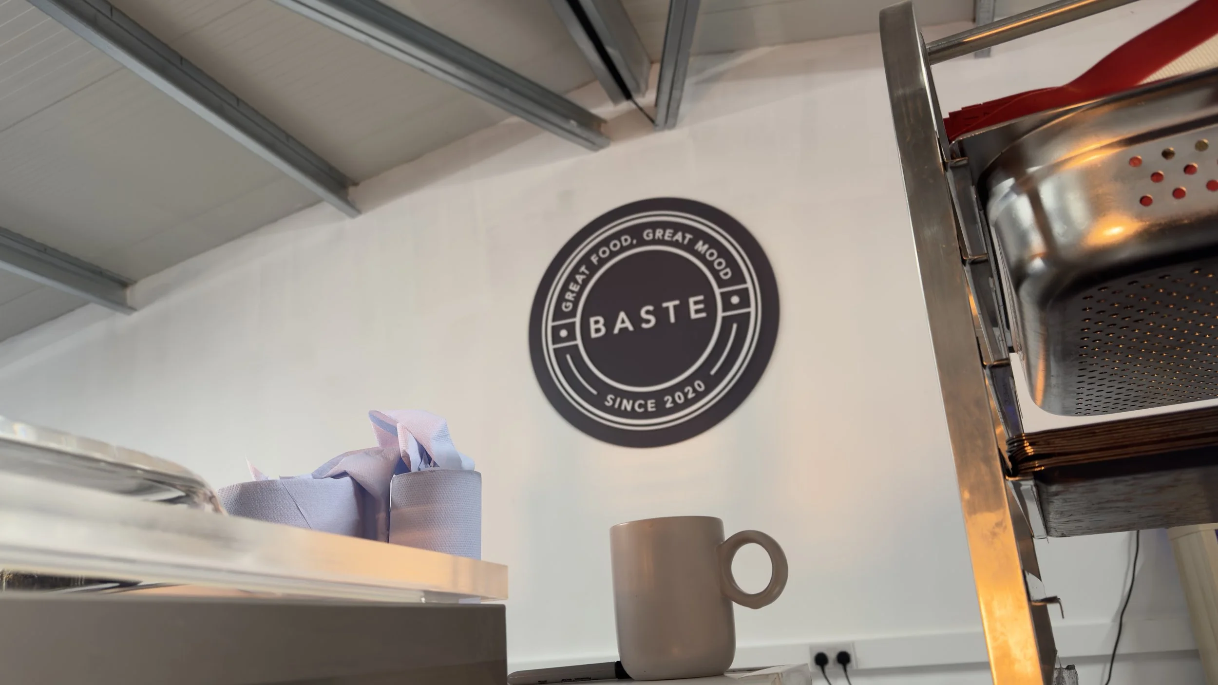 BASTE raised logo wall signage installed inside a hospitality space