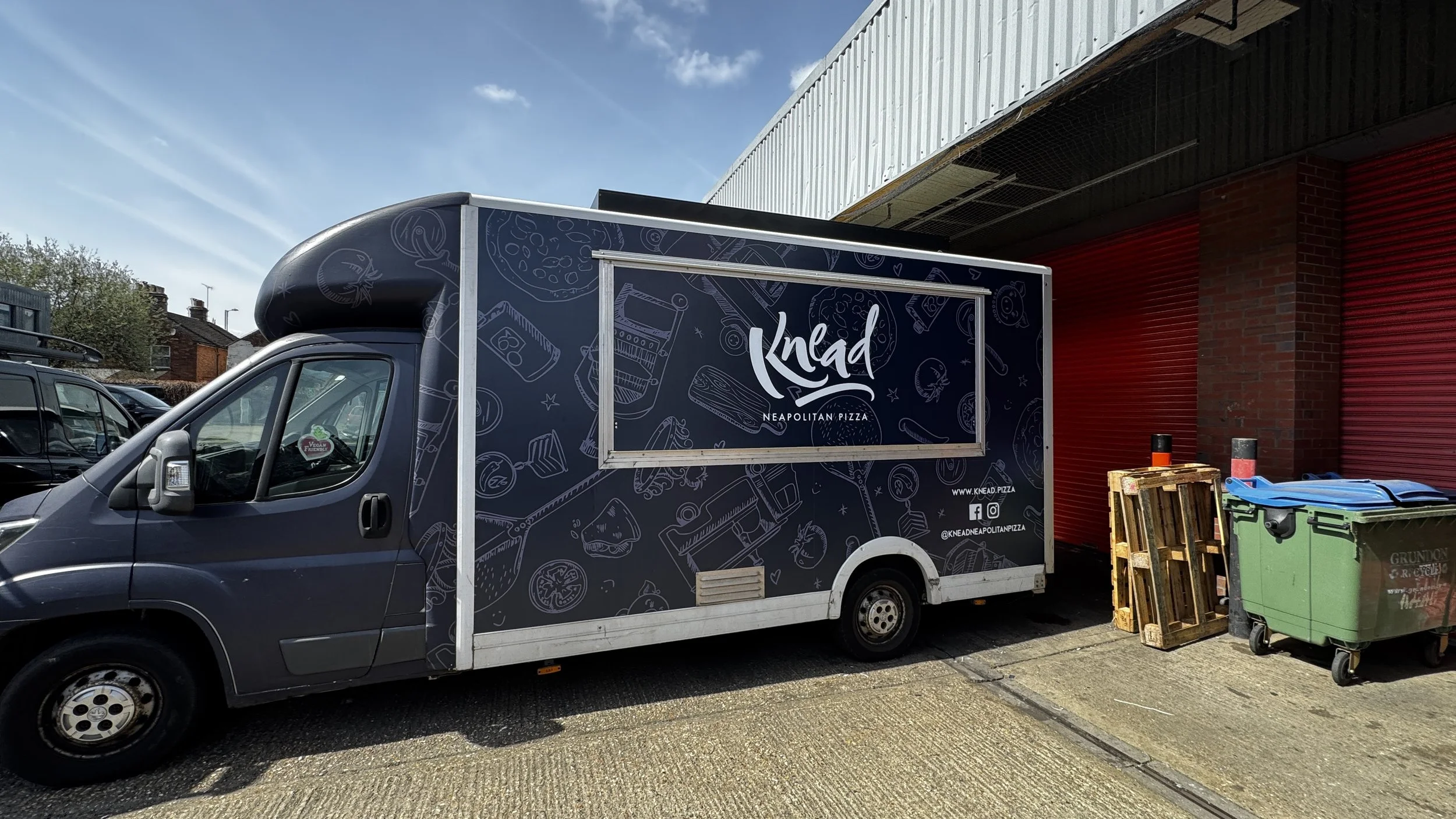 Navy blue Knead Pizza catering truck wrap with custom illustrated graphics and branded serving hatch.JPG