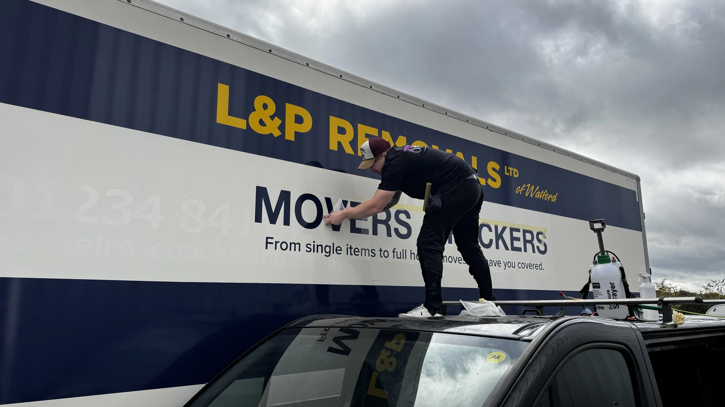 Toy Creative installing oversized vinyl lettering on L&P Removals commercial lorry in Luton.JPG