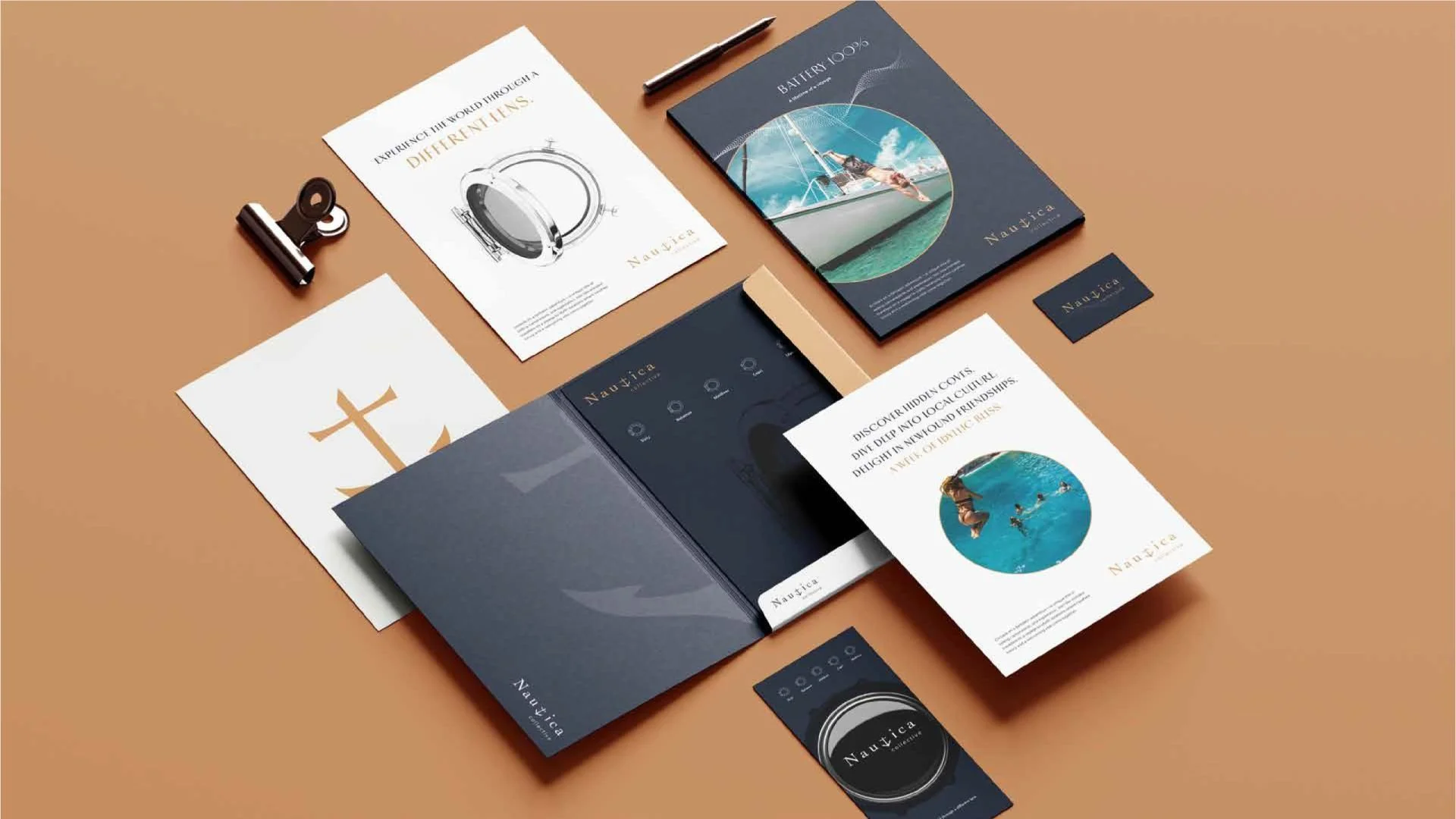 A collection of promotional materials and brochures for Nautica, related to sailing and diving, displayed on a brown surface with a black binder clip and a pen.