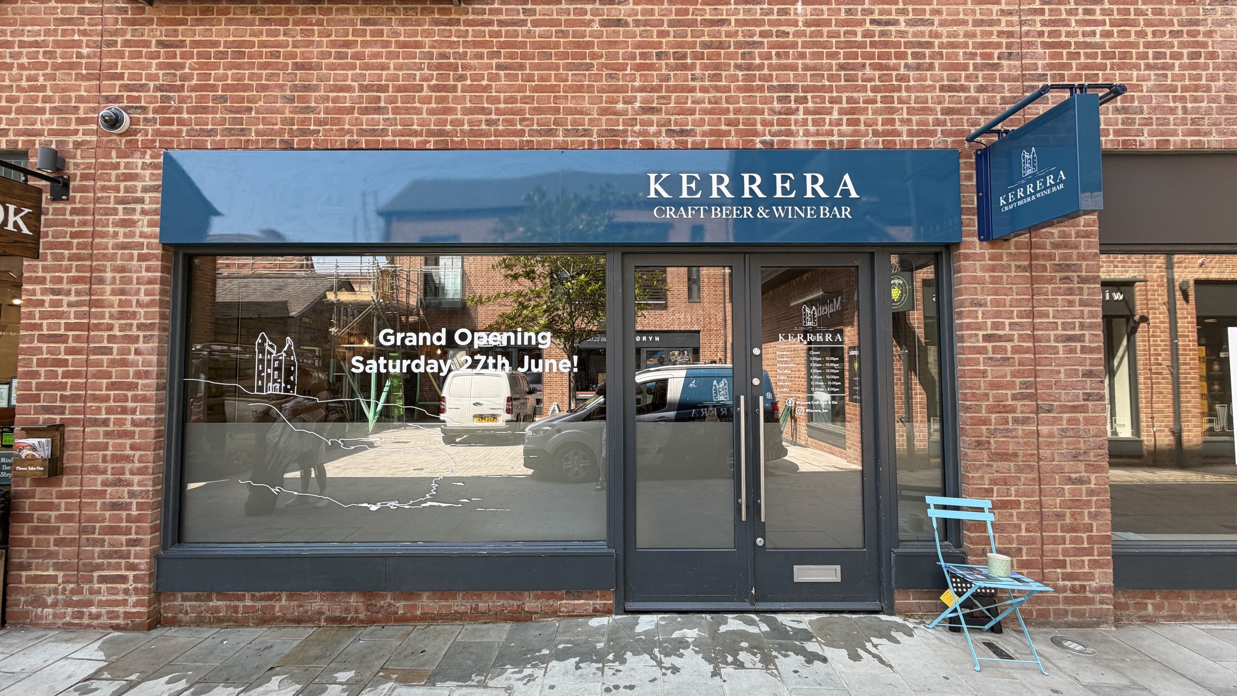 Exterior view of Kerrera Craft Beer & Wine Bar with signage indicating grand opening on Saturday, June 27, and large glass windows reflecting street scene.