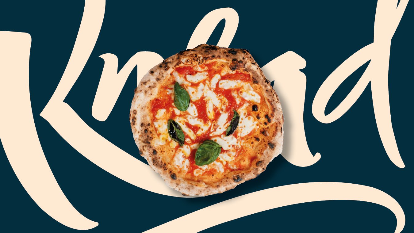 A margherita pizza with melted cheese, tomato sauce, and fresh basil leaves on a dark blue background with cream-colored text.