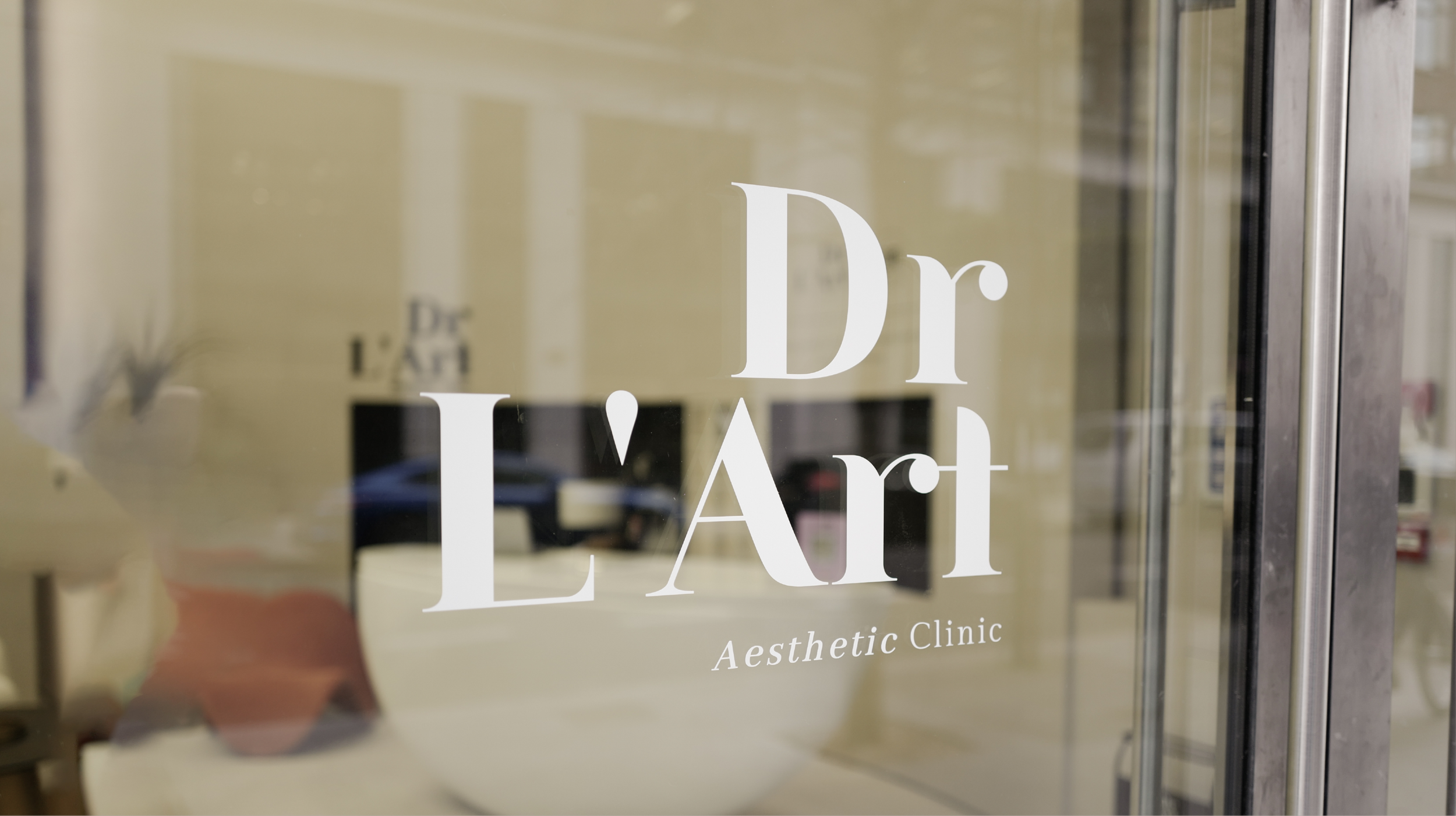 Glass door with the text "Dr. L'Art" and "Aesthetic Clinic" written on it.