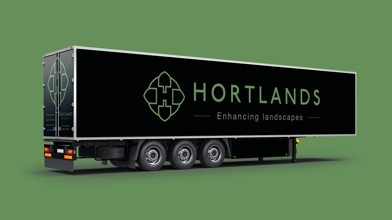 A black trailer truck with a green and white logo and text for 'Hortlands' on the side, parked on a green background.