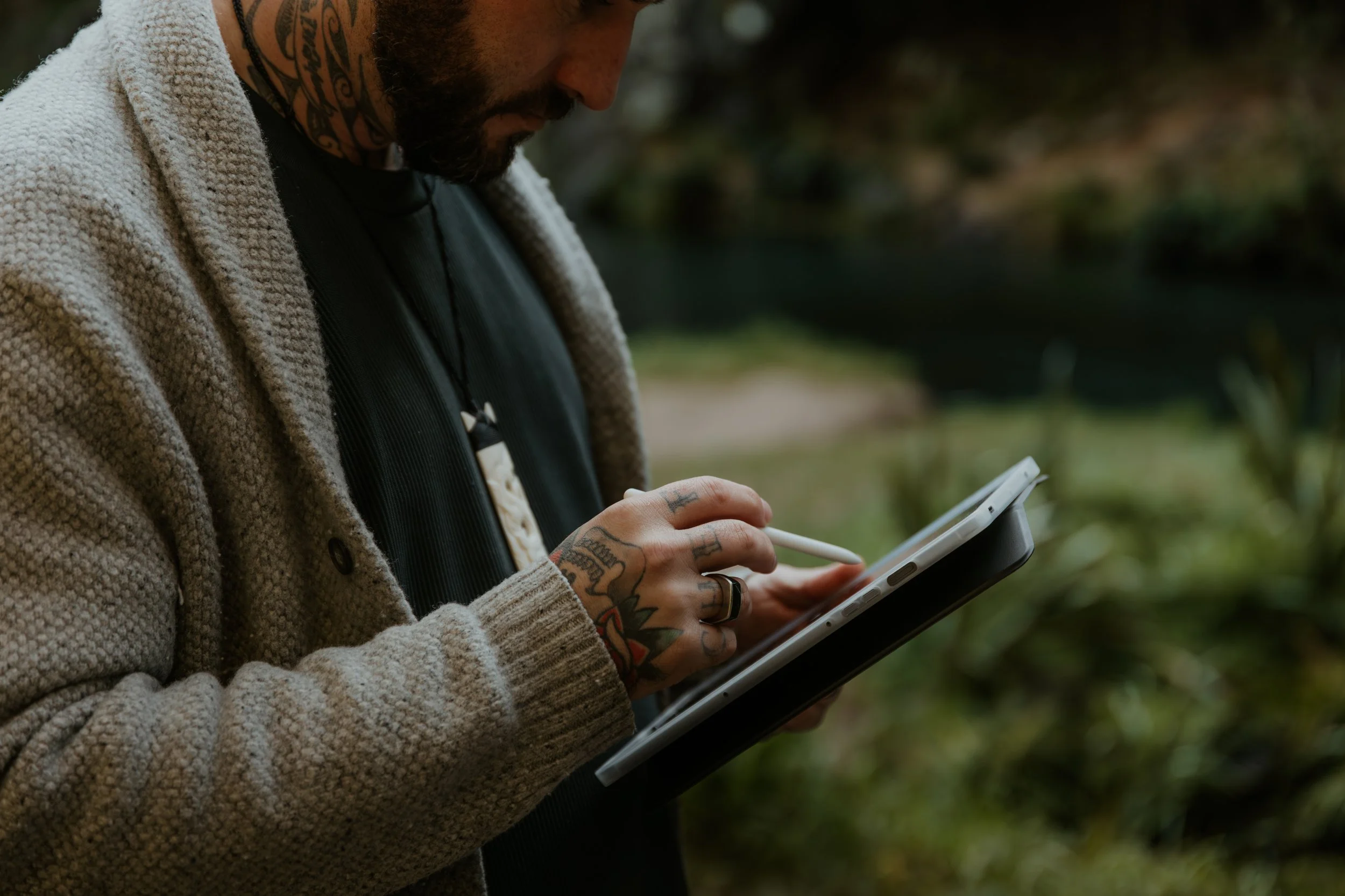 Josh using a tablet outdoors during a counselling session in a natural setting.