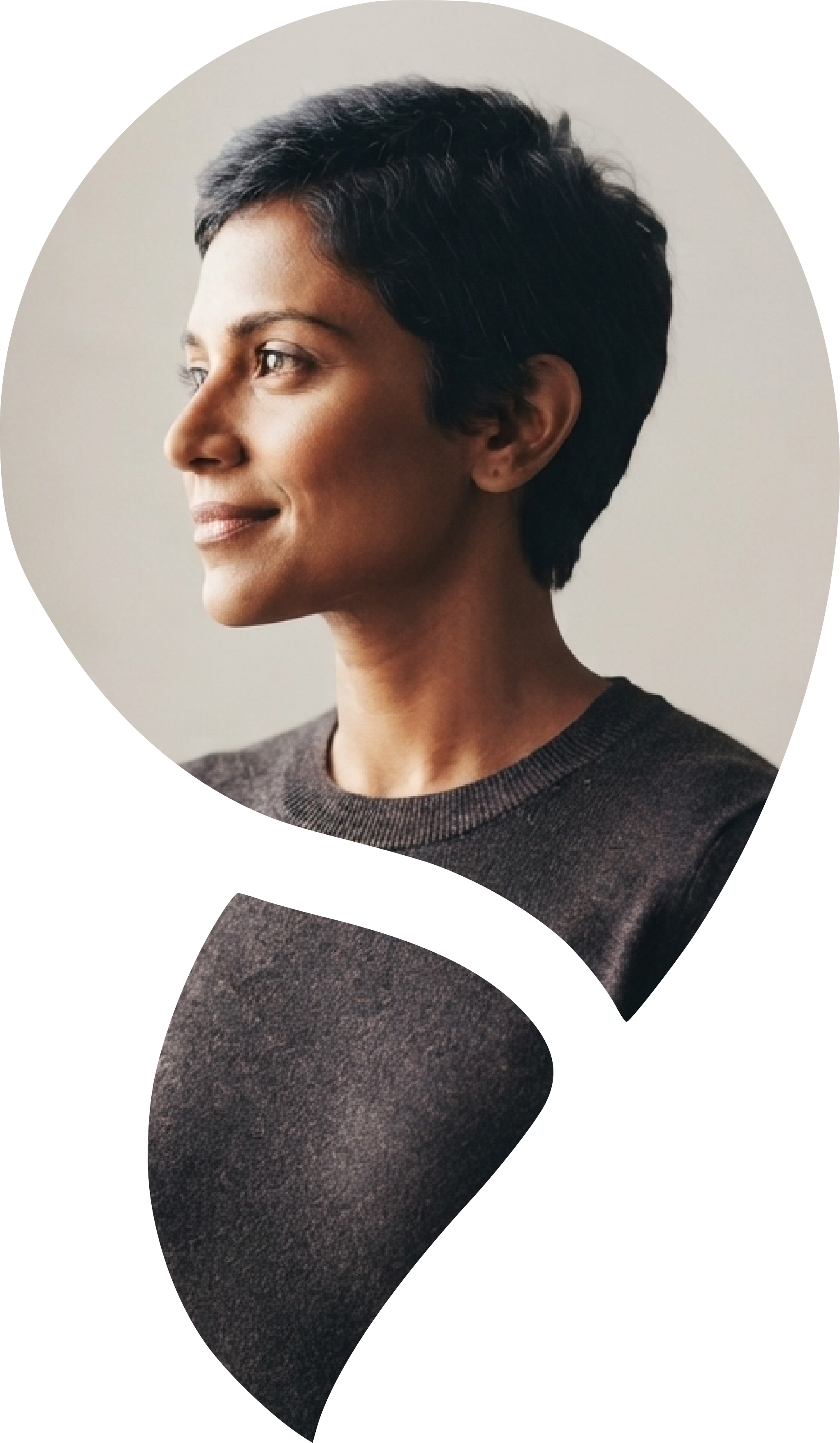 Side profile of a woman with short dark hair, wearing a dark shirt, looking to the left against a neutral background.