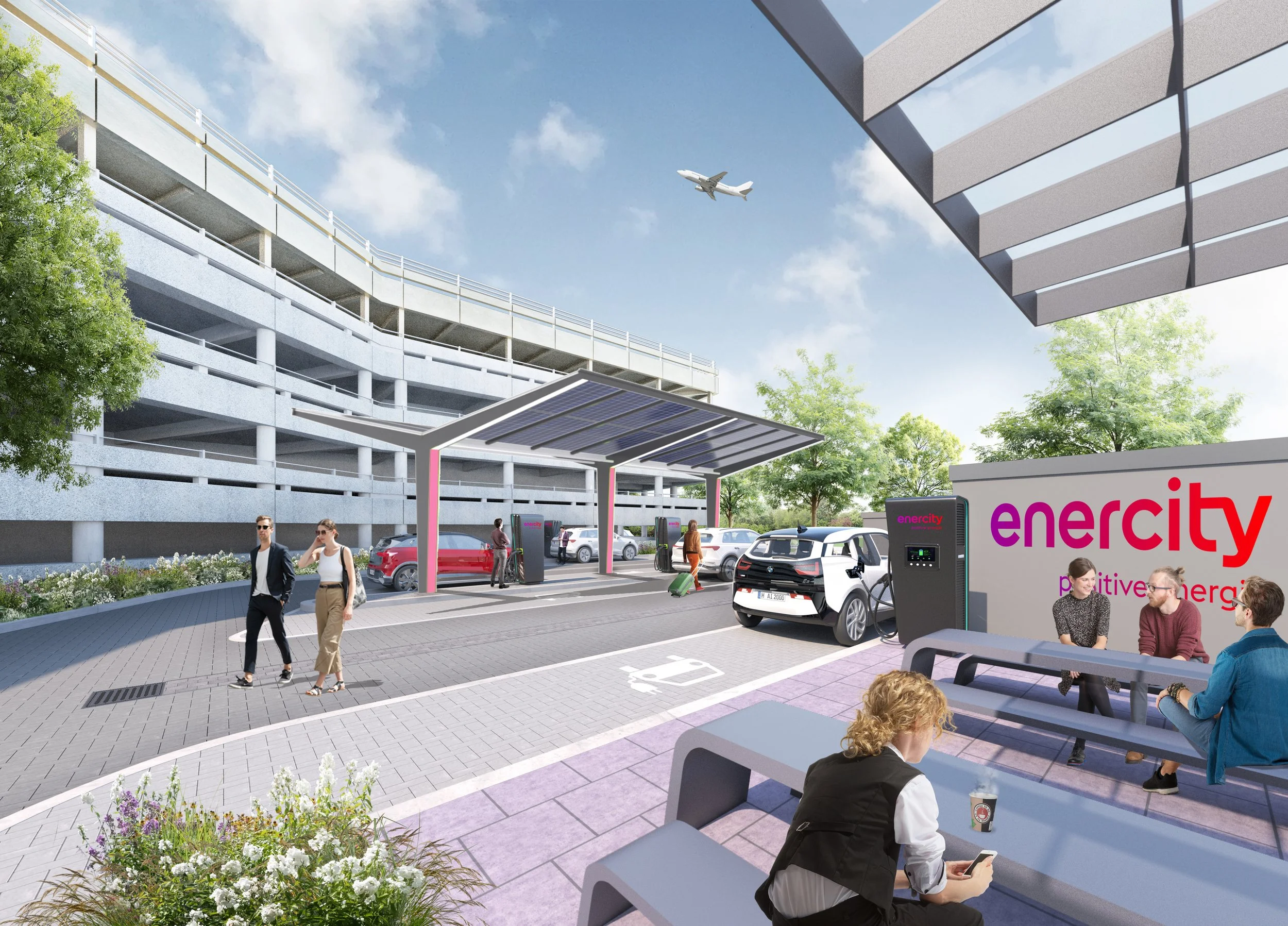 Menschen warten an einer Ladestation für Elektroautos in einer Parkgarage, während im Hintergrund ein Flugzeug am Himmel fliegt.