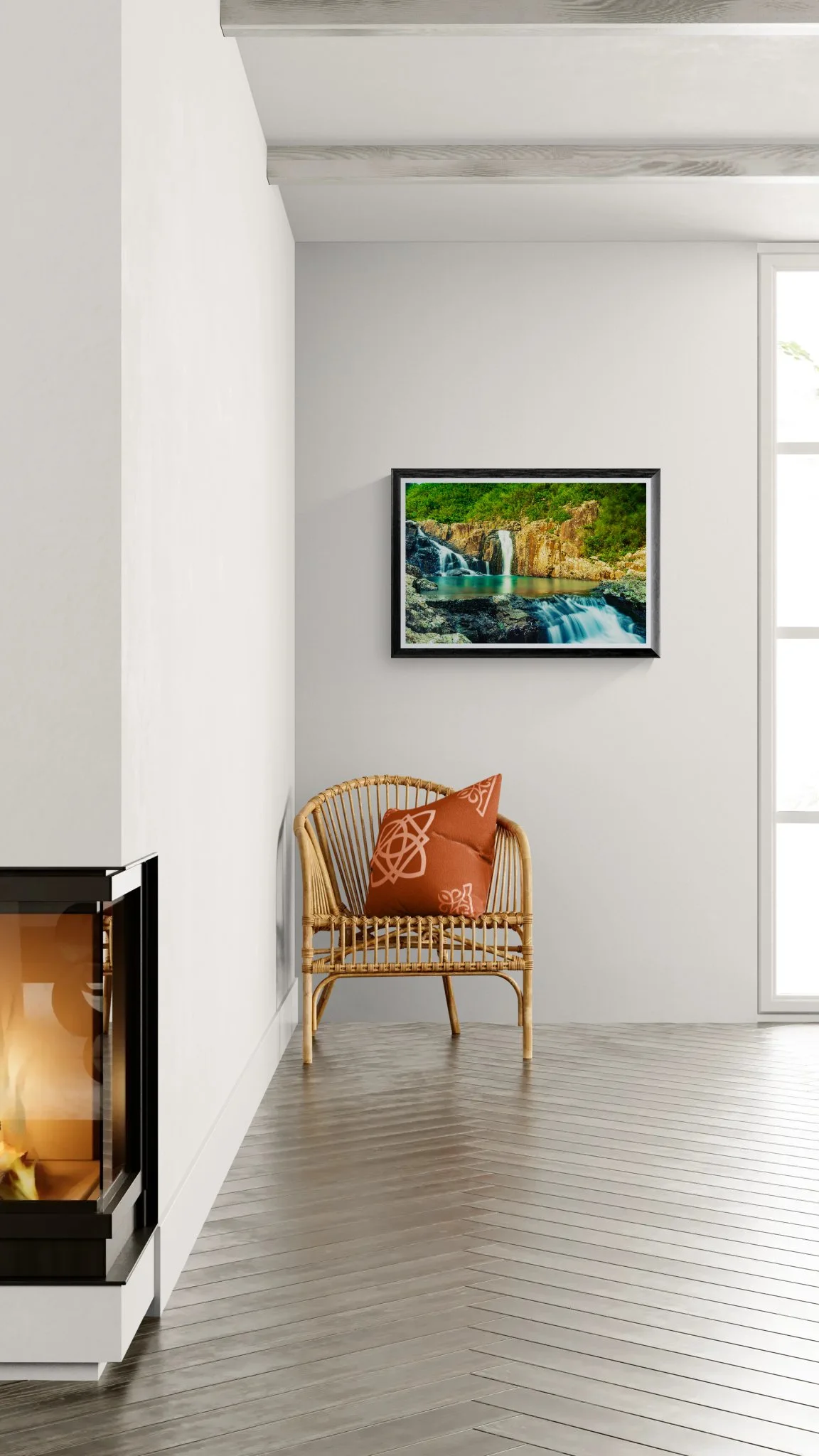 Interior wall mockup displaying a framed fine art waterfall print above a woven rattan chair in a bright minimalist room.