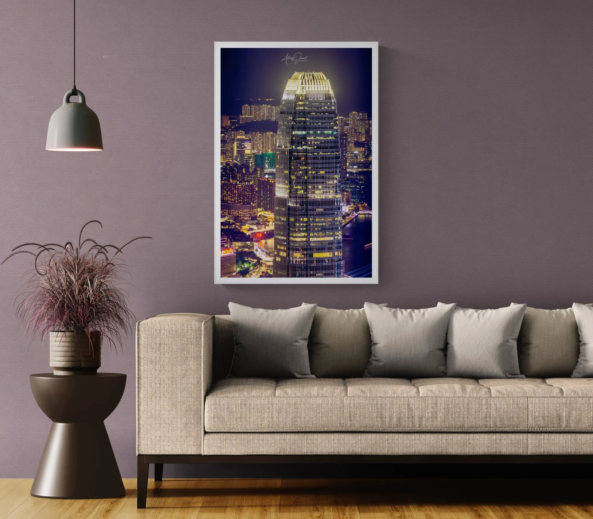Framed 2 IFC Hong Kong night print hanging on a dark wall above a modern grey sofa in a styled interior.