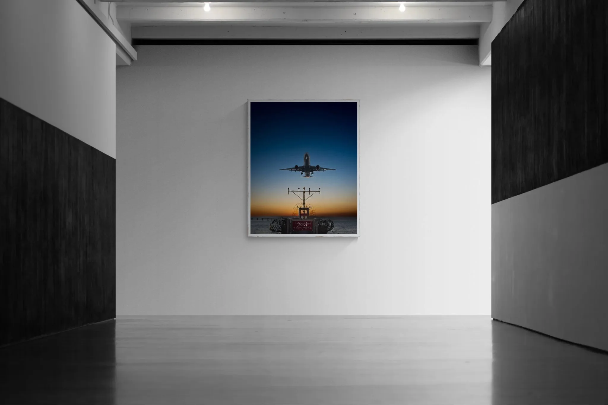 Large framed aviation fine art print displayed on a minimalist white wall inside a modern, spacious art gallery with dark wood paneled accent walls