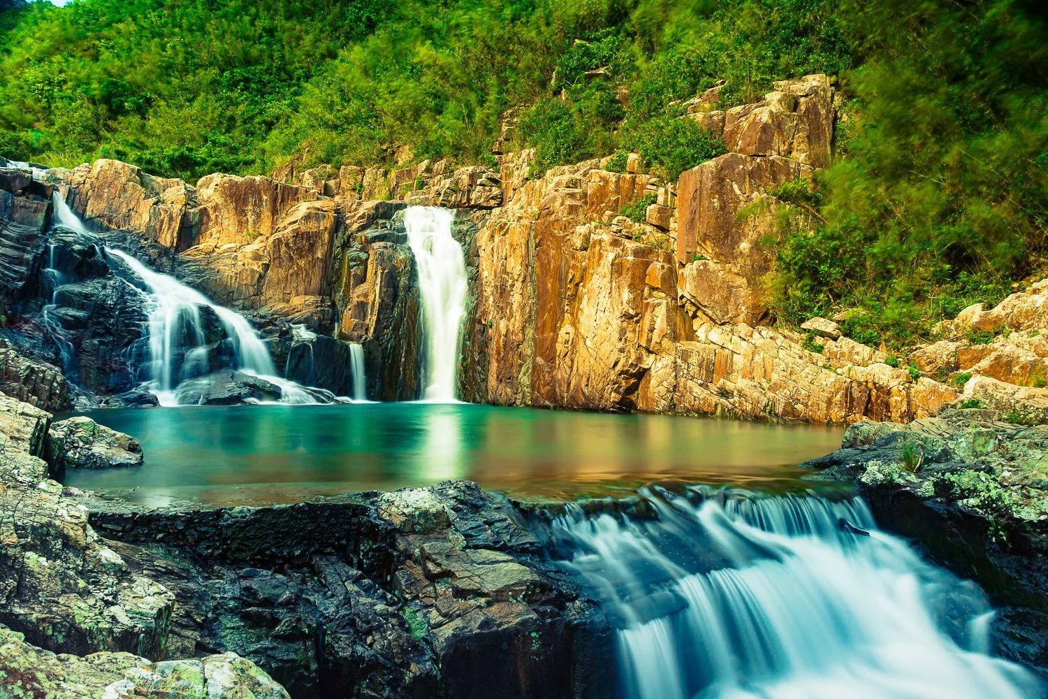Fine art  long-exposure waterfall landscape Sai Kung, Hong Kong, featuring rocky cliffs, lush greenery, and a tranquil atmosphere.