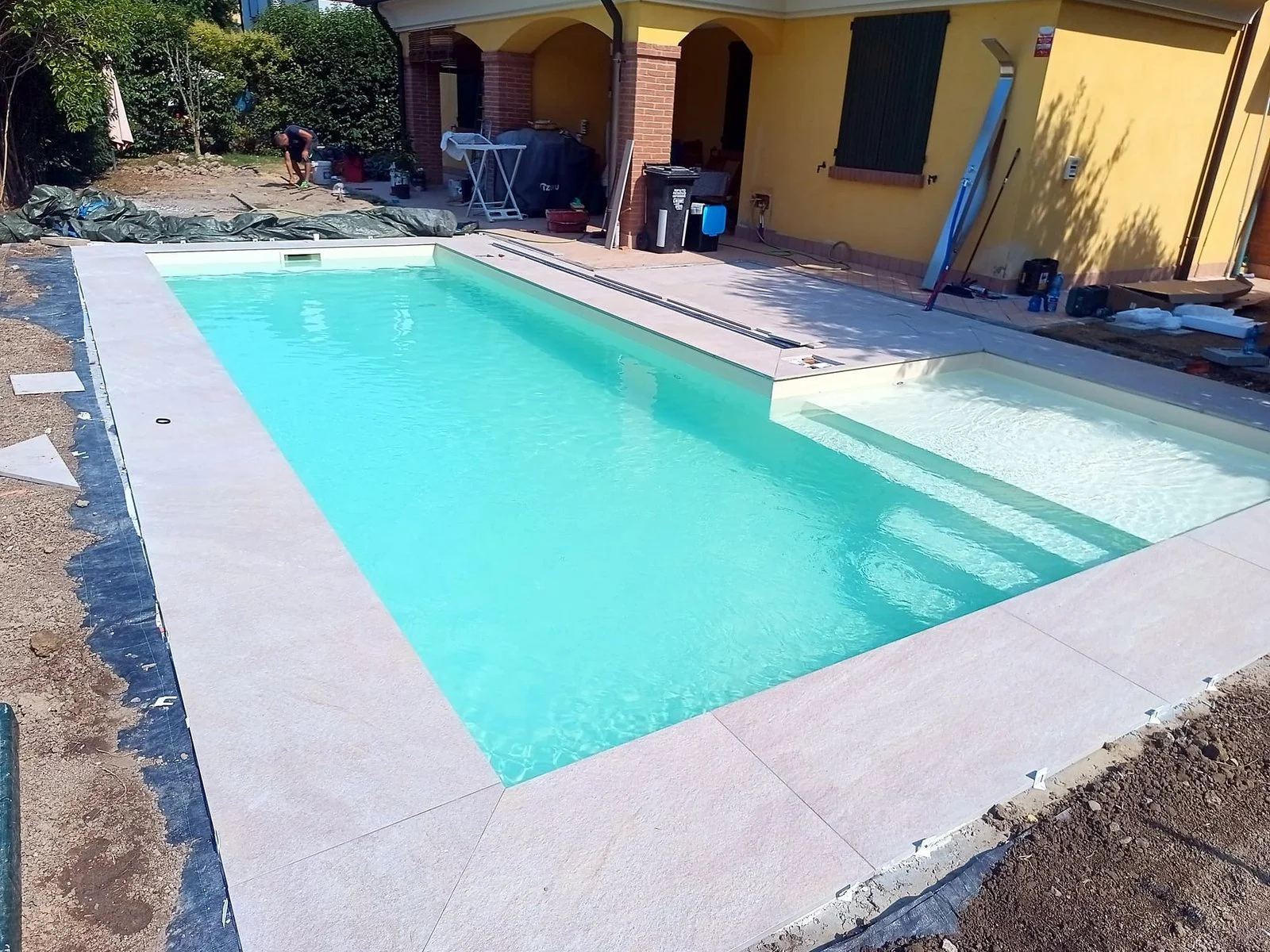 Piscina interrata con bordo in pietra realizzata da Lavoro369