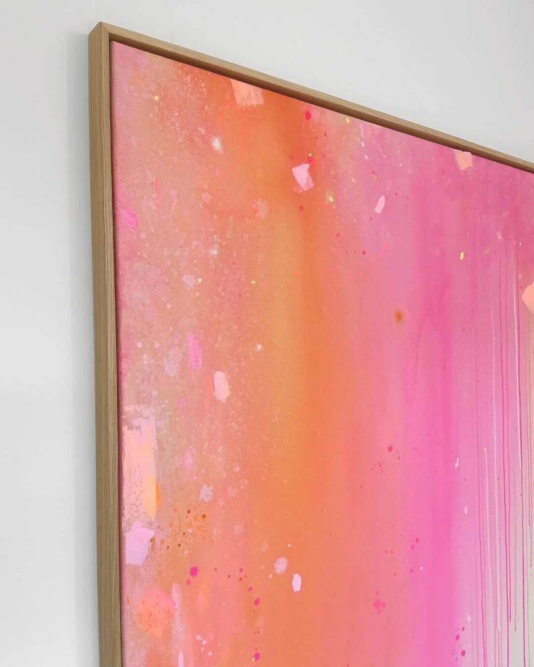 Detail shot showing the soft blending of orange, rose, and pink paint with subtle texture and dripping effects