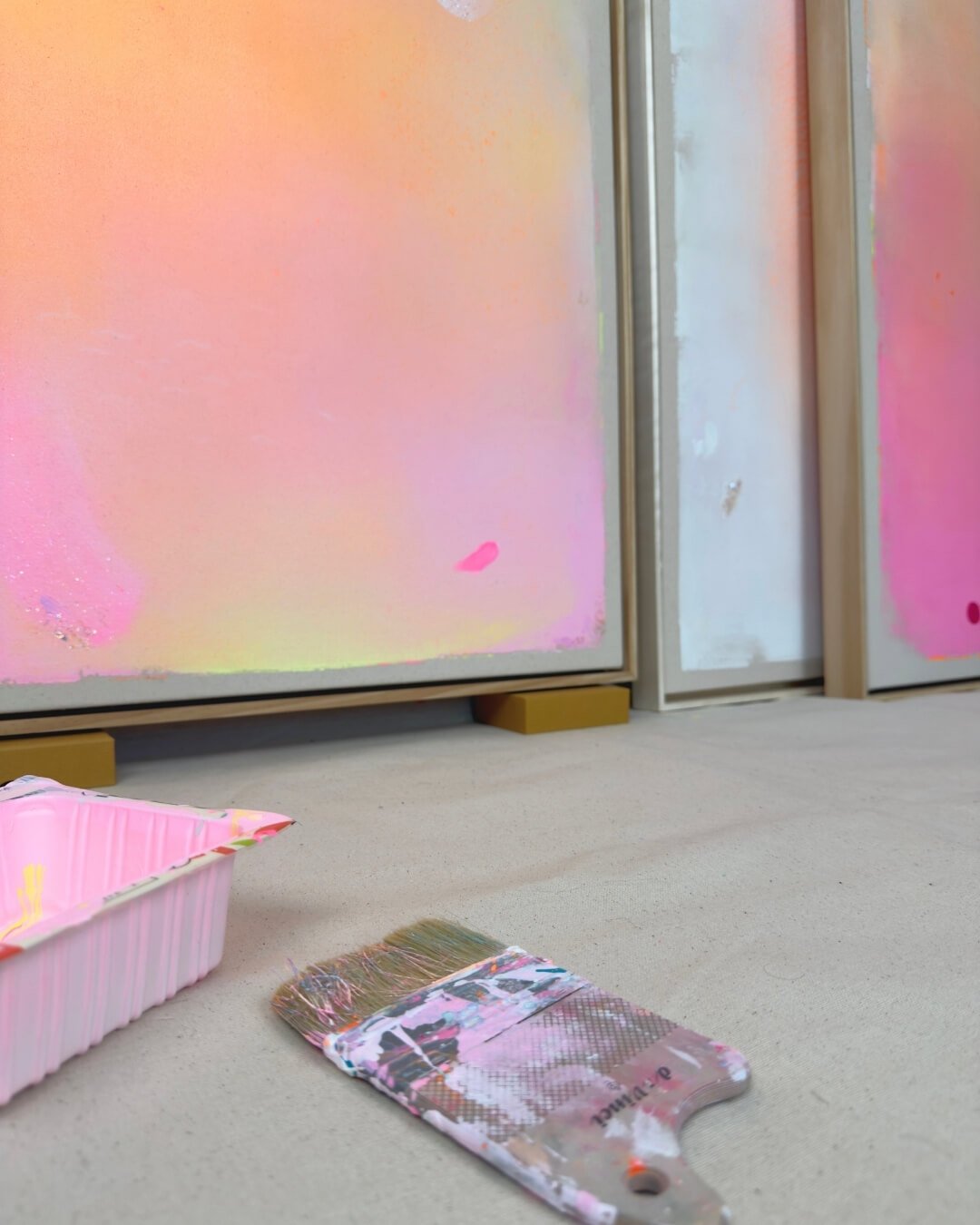 Close-up detail of subtle glitter accents and smooth color transitions in purple, pink, orange, and yellow on a canvas by Vanessa Ochi