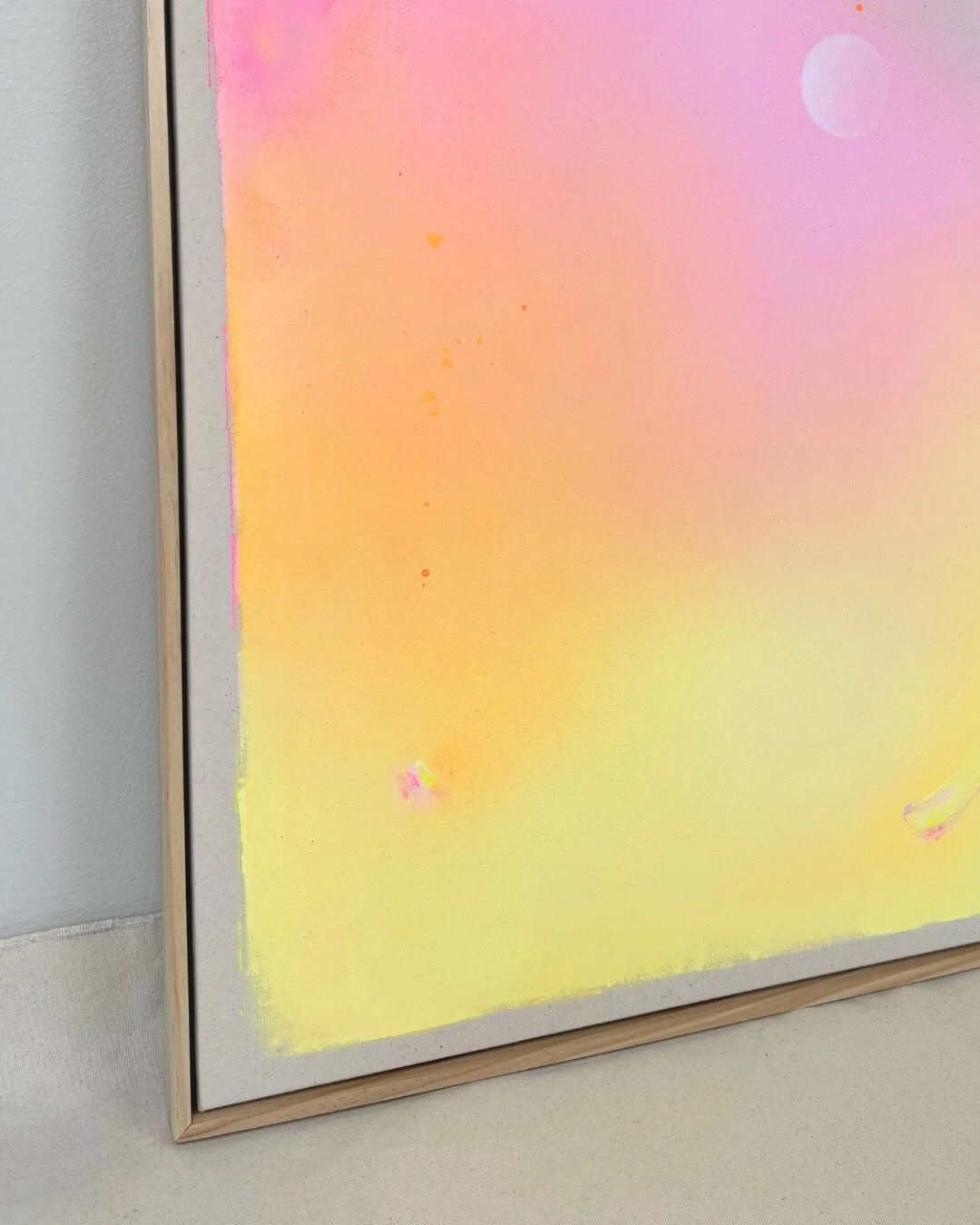 Close-up detail of subtle glitter accents and smooth color transitions in purple, pink, orange, and yellow on a canvas by Vanessa Ochi.