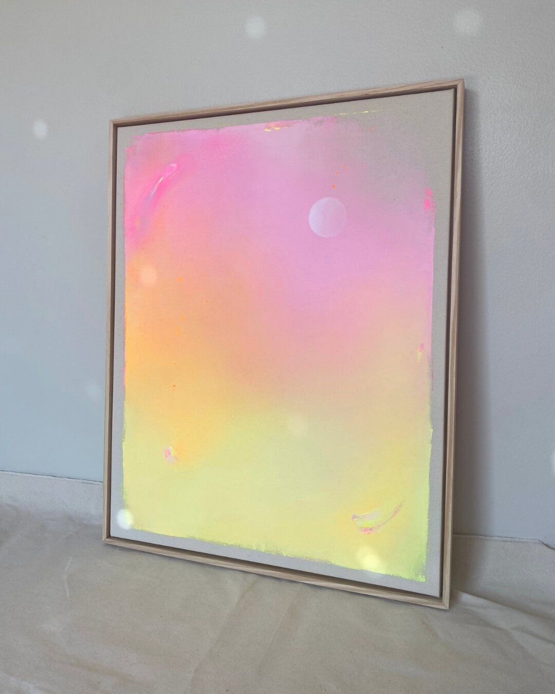 Dreamy abstract canvas art depicting a glowing white full moon with subtle sparkle set against a vibrant purple, pink, orange, and yellow gradient by Vanessa Ochi.