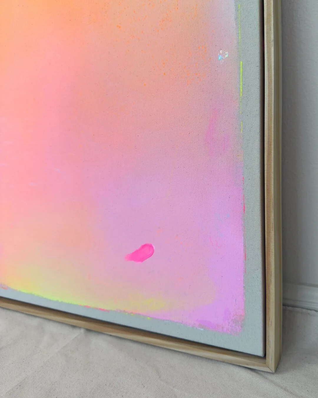 Close-up detail of subtle glitter accents and smooth color transitions in purple, pink, orange, and yellow on a canvas by Vanessa Ochi