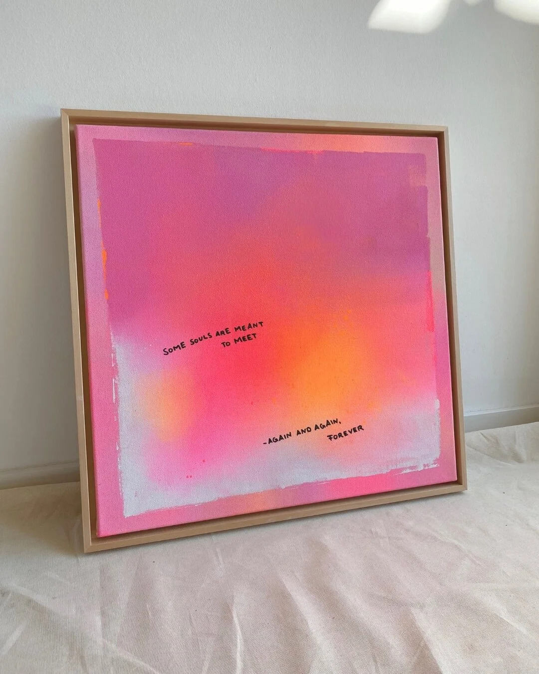 Vibrant abstract painting with smooth color transitions from glowing neon orange to soft pink, centered around a written quote about human connection by Vanessa Ochi.