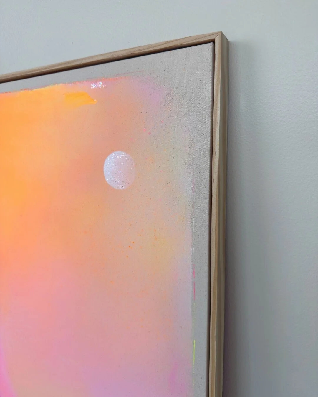 Close-up detail of subtle glitter accents and smooth color transitions in purple, pink, orange, and yellow on a canvas by Vanessa Ochi