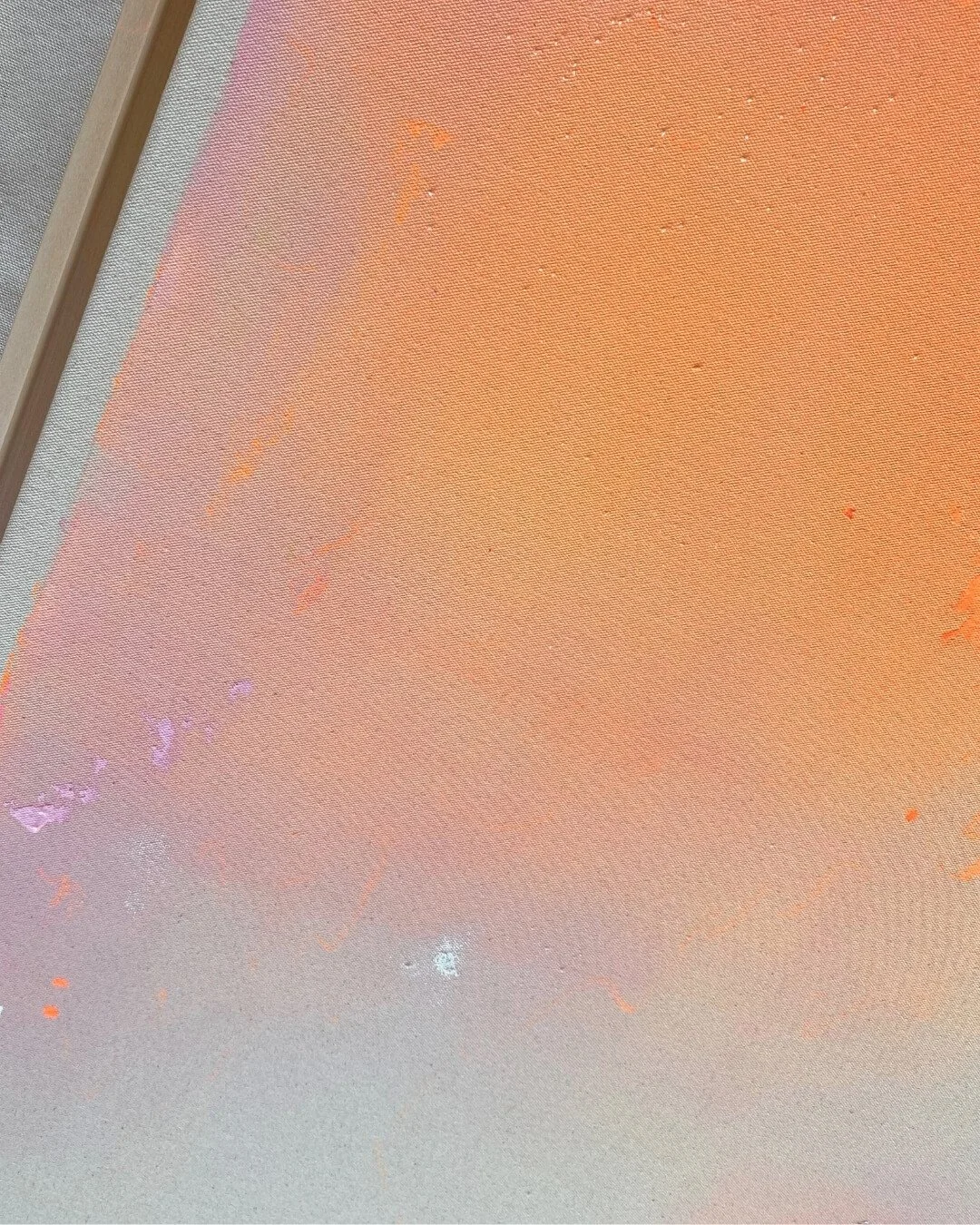 Angled shot of the framed original painting Peachy Glow Dust I, highlighting how light catches the textured surface and soft peach tones by Vanessa Ochi