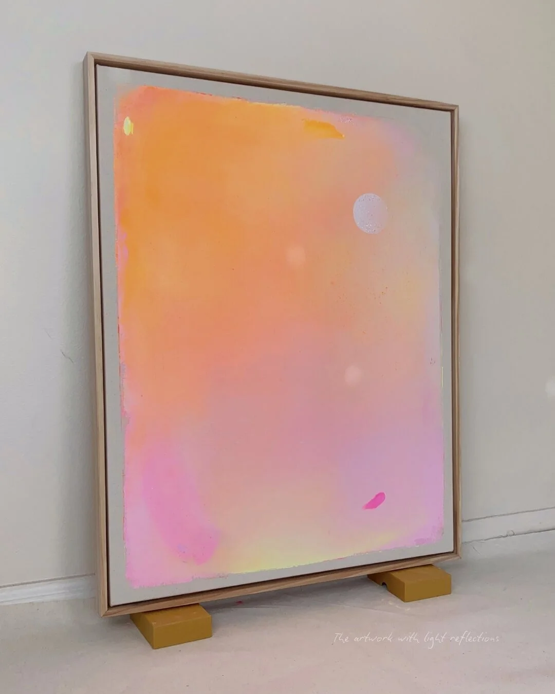 Original abstract night sky painting featuring a white full moon, subtle glitter, and a radiant gradient of pink, orange, yellow, and purple by Vanessa Ochi