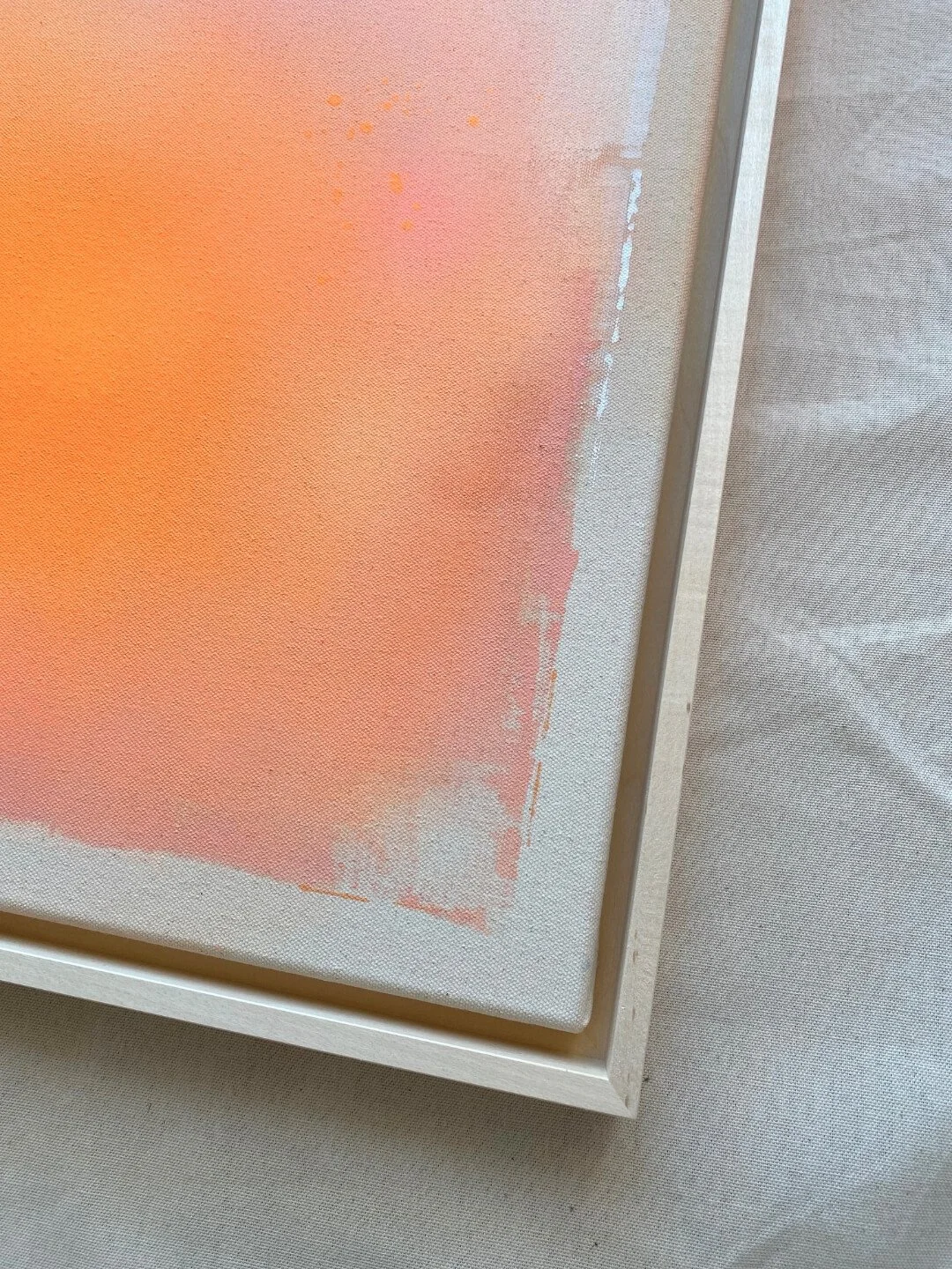 Detail shot focusing on the luminous white and warm rose-pink paint blending on canvas, symbolizing shared energy and warmth by Vanessa Ochi.