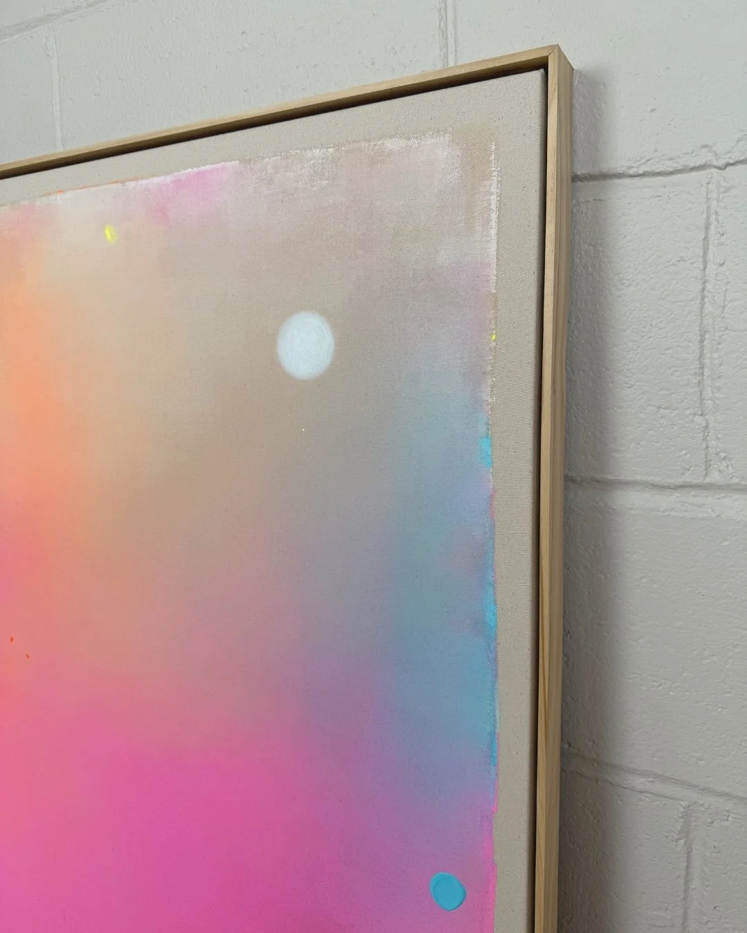 Close-up detail of a canvas art piece showing the shimmering, rainbow-like holographic effect of the full moon over smooth pink and blue paint gradients by Vanessa Ochi