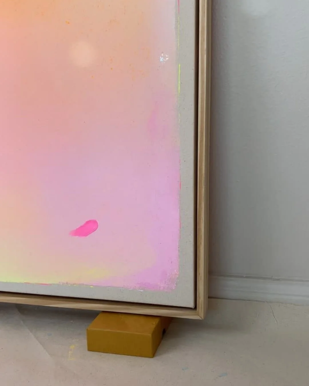 Close-up detail of subtle glitter accents and smooth color transitions in purple, pink, orange, and yellow on a canvas by Vanessa Ochi