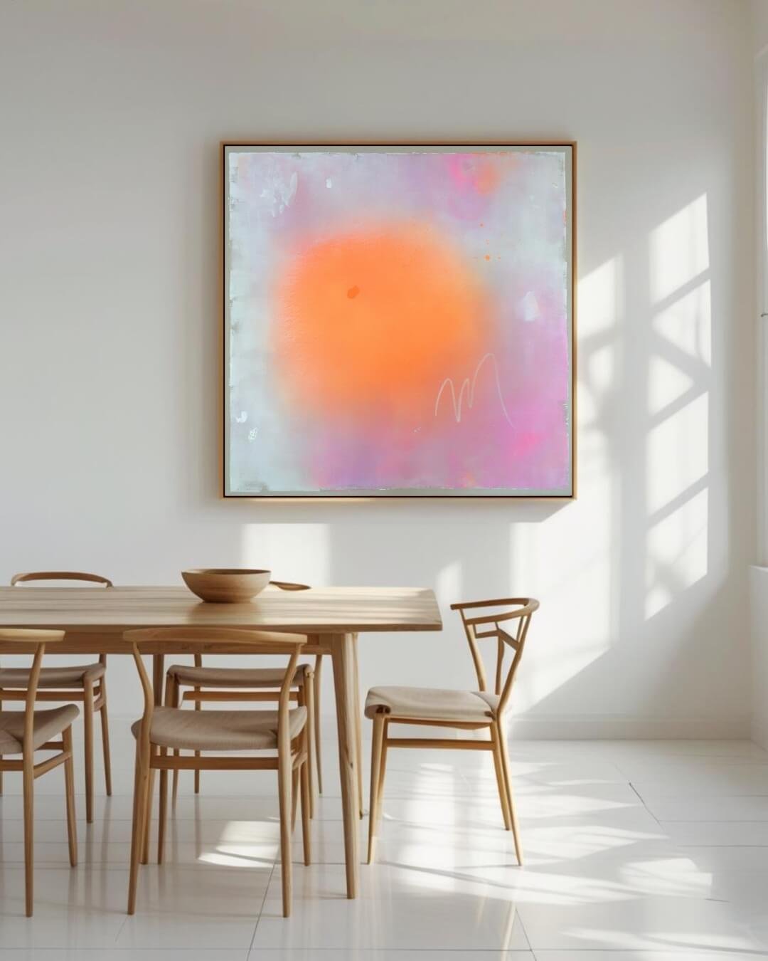 Modern dinning room styled with a large pink, orange, and white abstract sun painting with subtle glitter mounted on a neutral wall