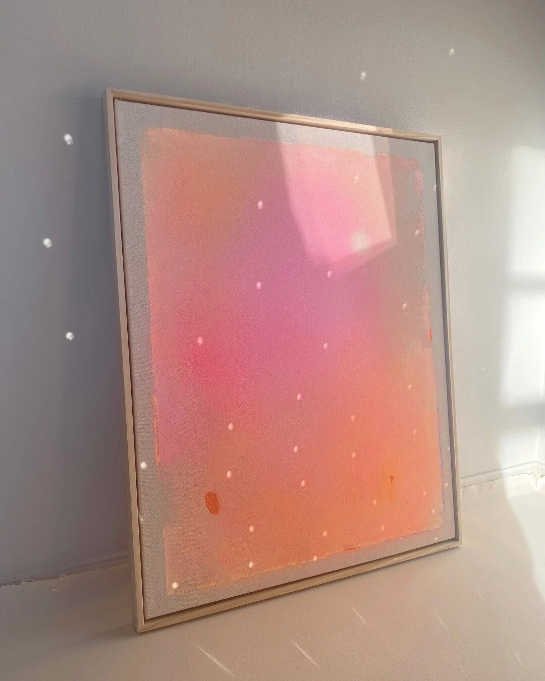 Original abstract night sky painting featuring a white full moon, subtle glitter, and a radiant gradient of pink, orange, yellow, and purple by Vanessa Ochi