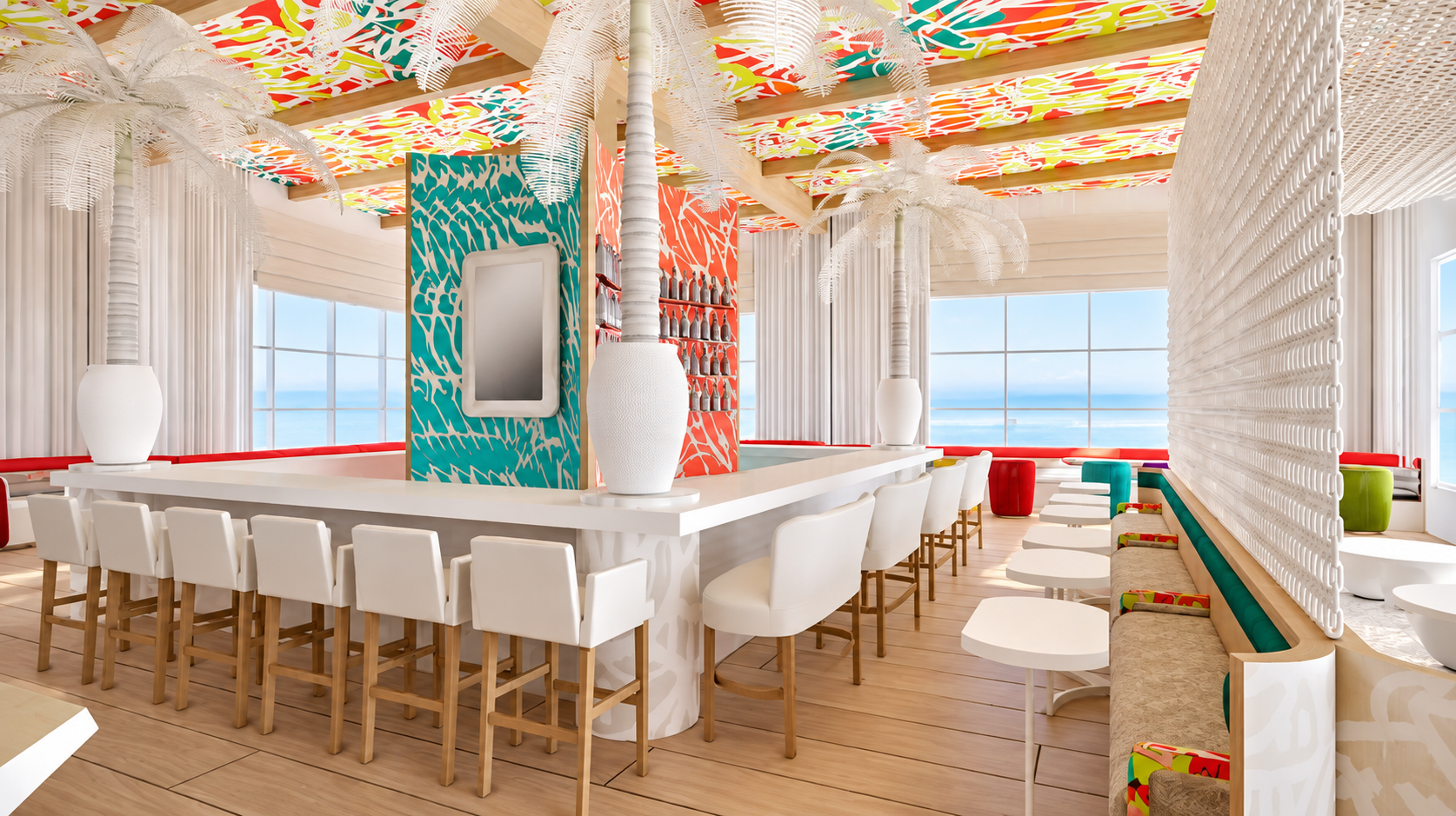 Interior of a bright, colorful restaurant with tropical decor, including white bar stools, white chairs, and a vibrant, patterned ceiling. Large windows offer a view of the ocean.