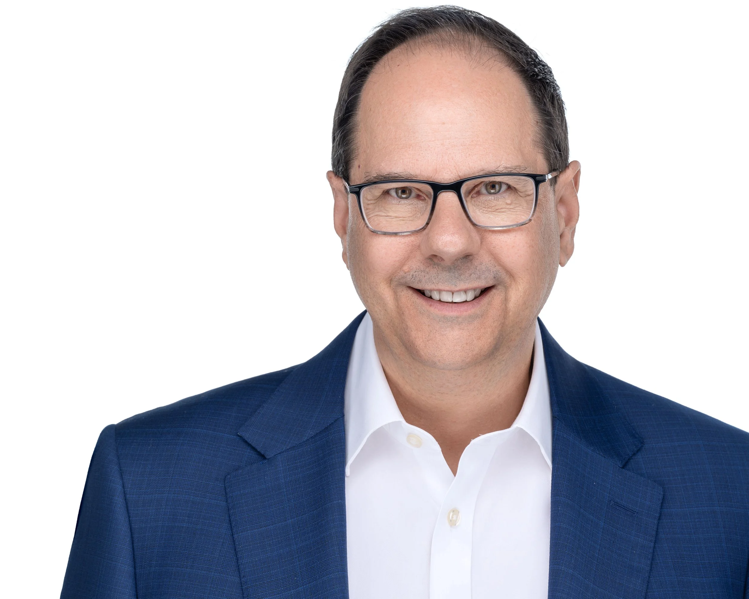 Man wearing glasses, blue suit, and white shirt, smiling, against a white background.